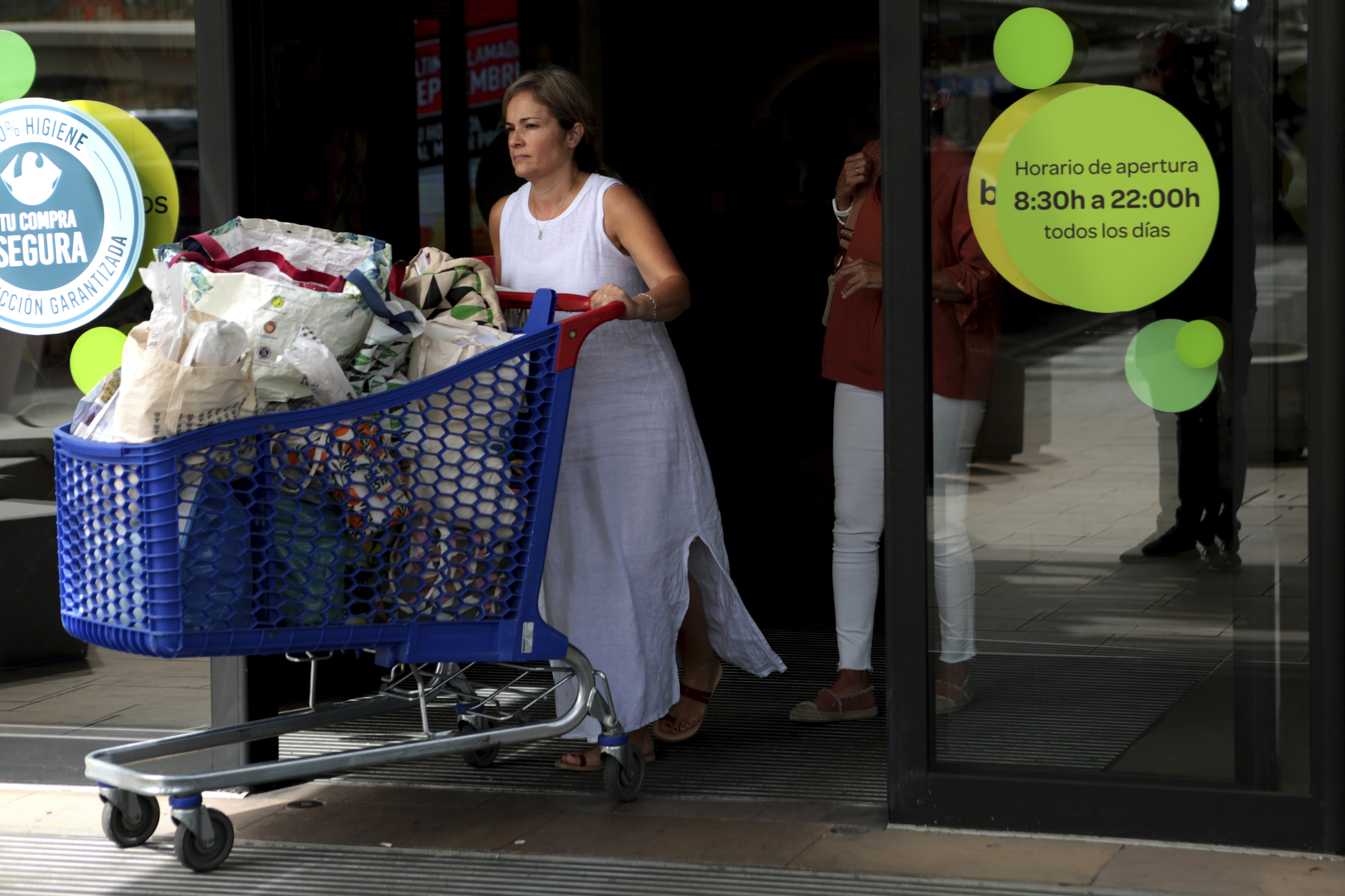 Una mujer sale de hacer la compra en el supermercado