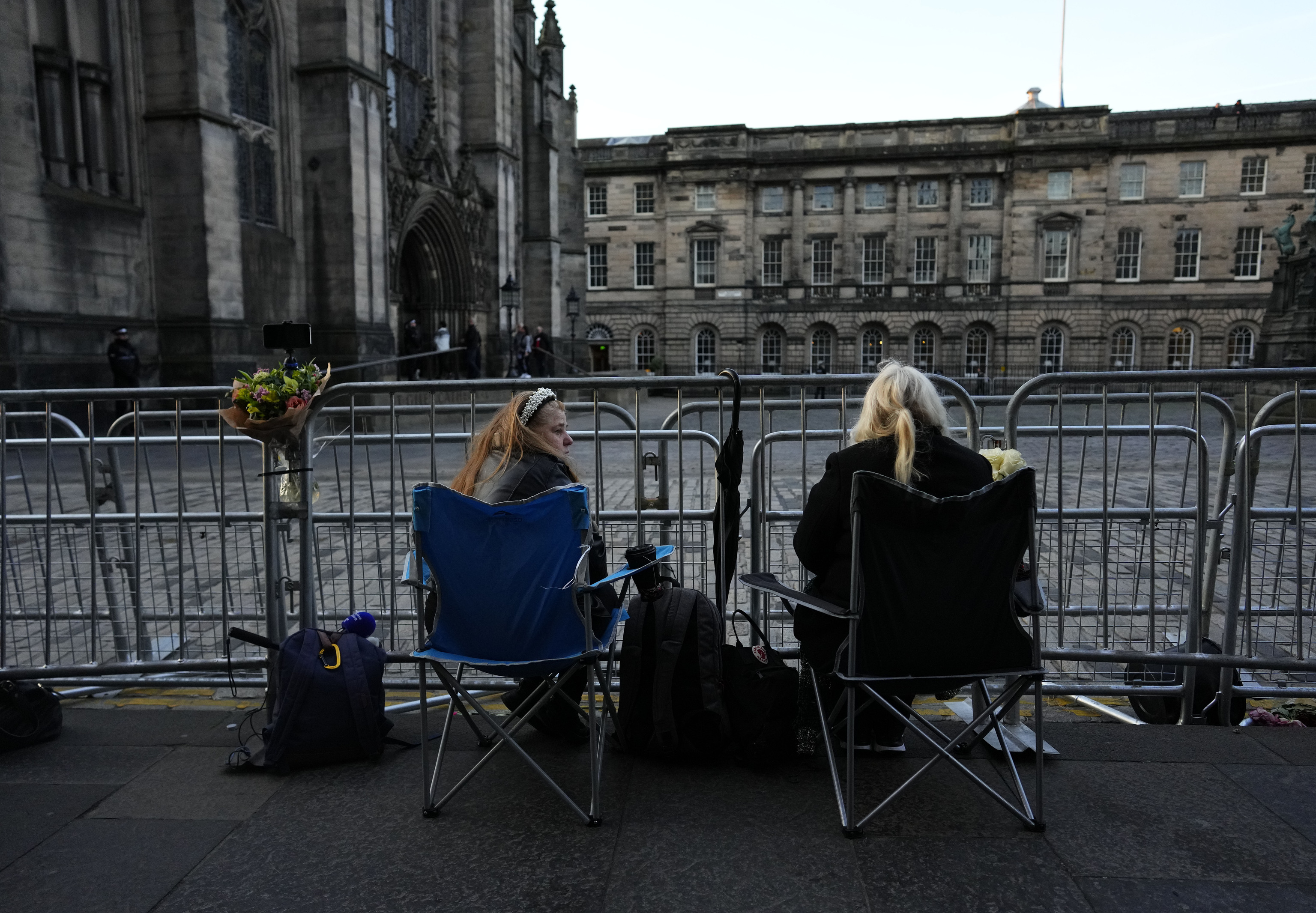 Dos mujeres esperan esta madrugada para ver el ataúd de la reina Isabel II mientras descansa en la catedral de San Giles en Edimburgo, Escocia.