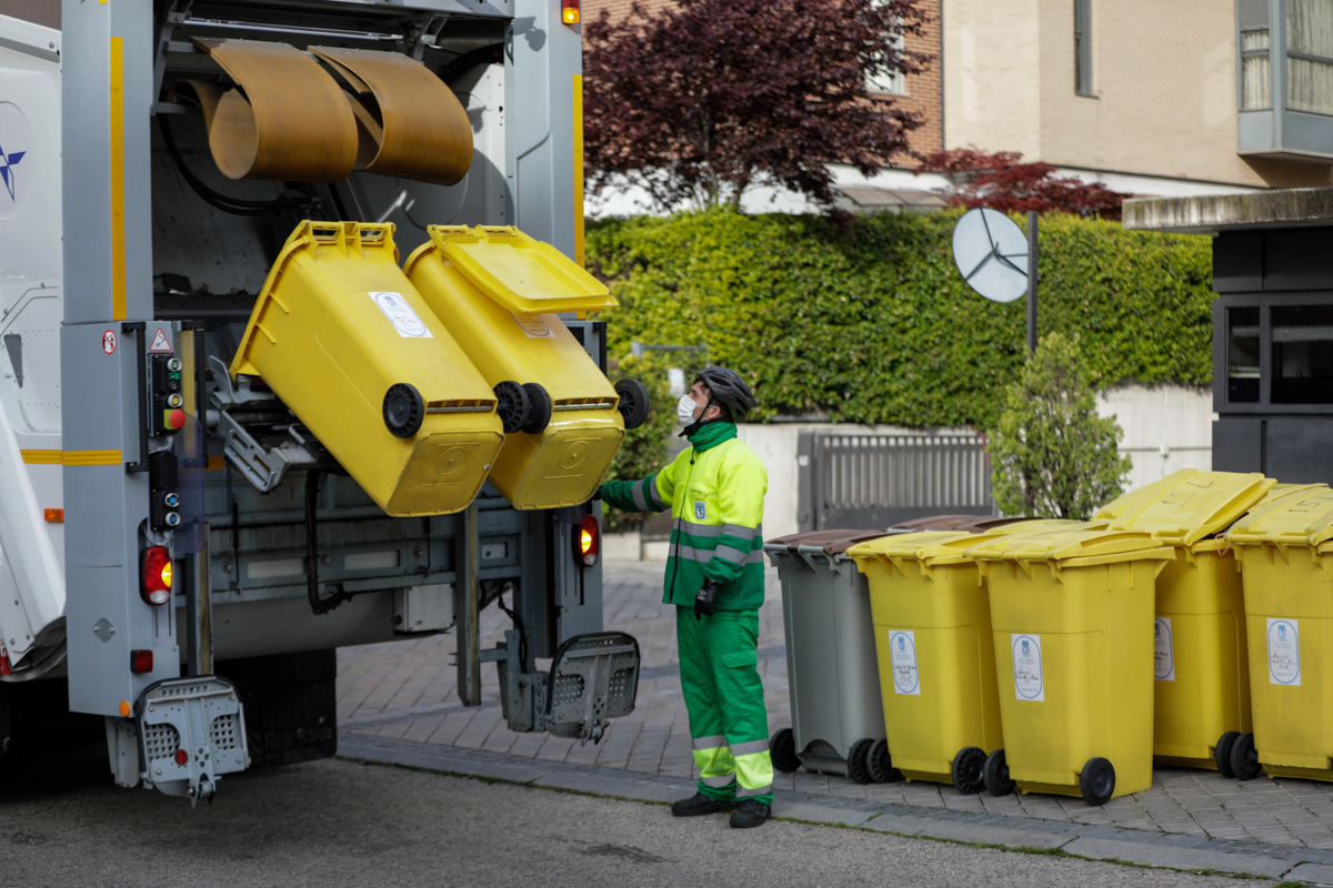 Un trabajador llena el camión de la basura con cubos amarillos, en Madrid.