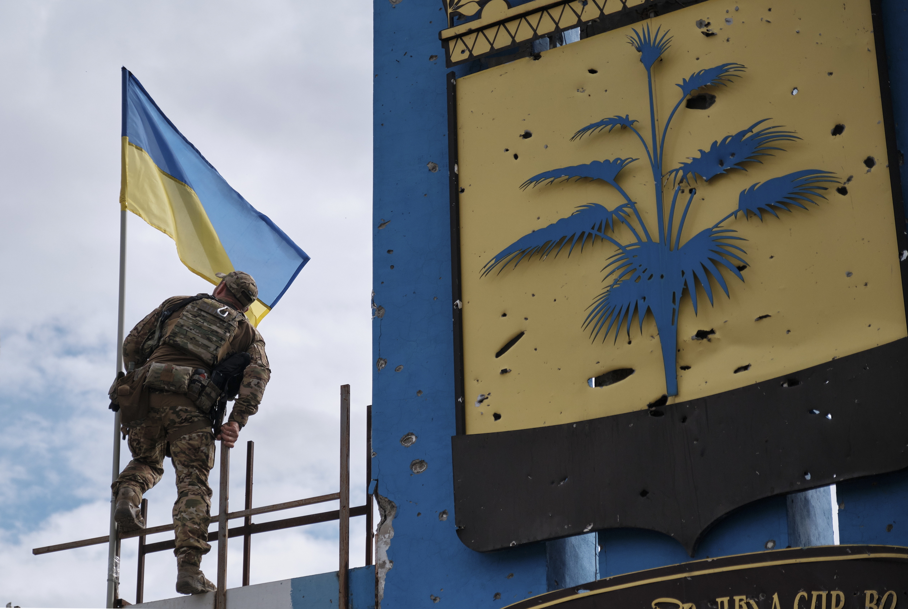 Un soldado ucraniano coloca la bandera nacional junto a Járkov.