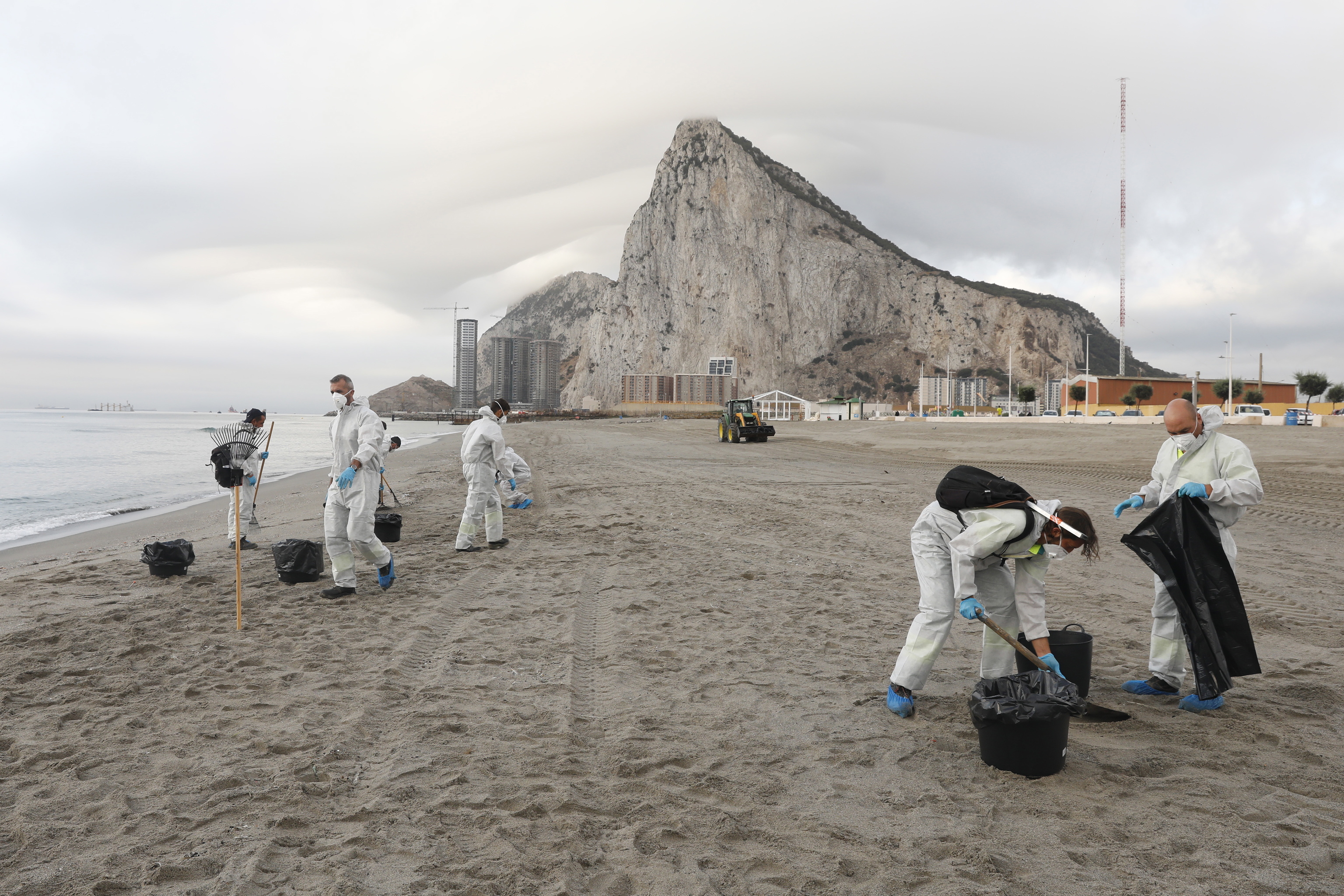 Limpieza en una playa de La Lnea, con Gibraltar al fondo, este mircoles.