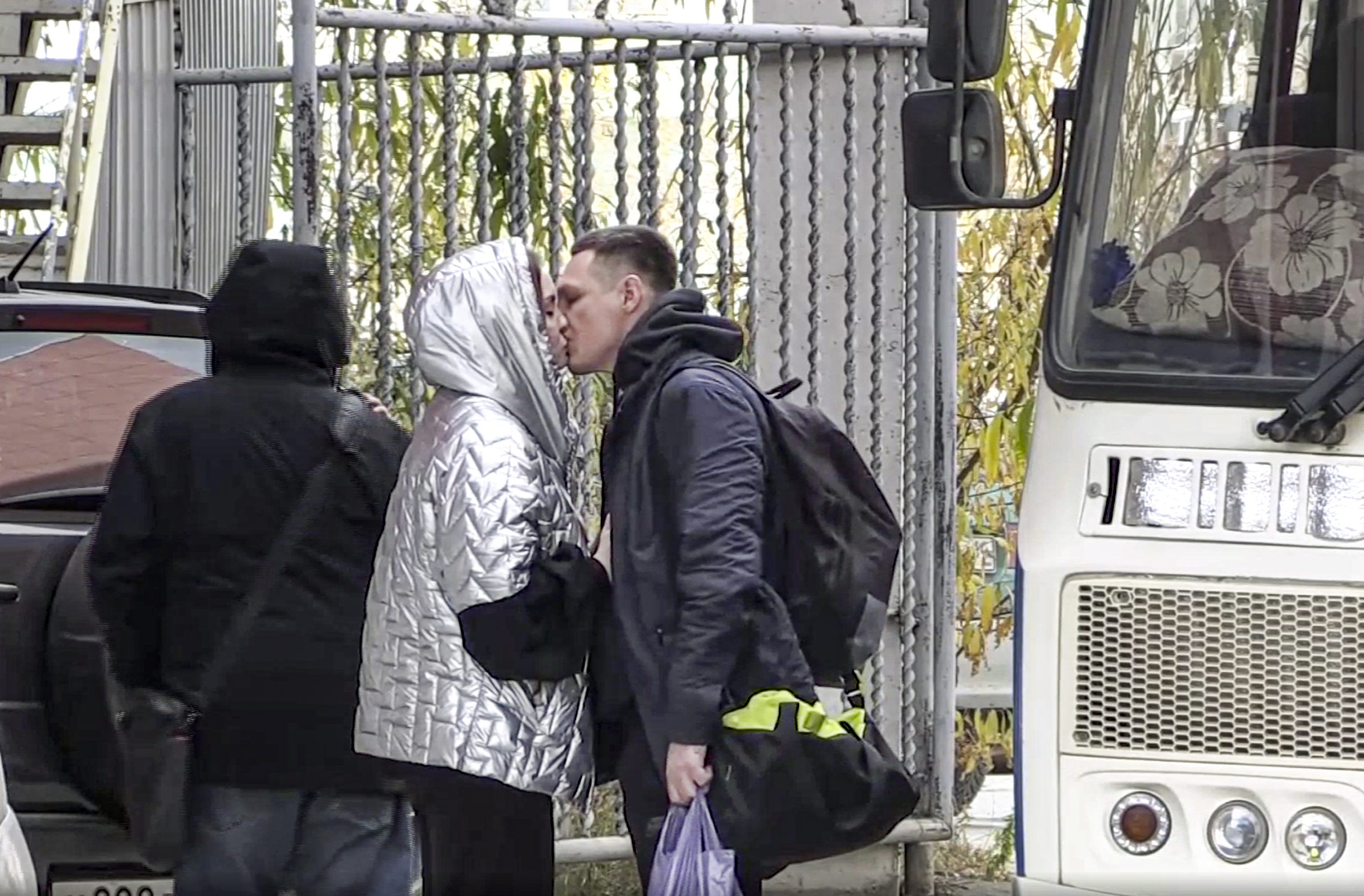 Un reservista ruso besa a su pareja antes de tomar el bus que le pondrá camino de Ucrania.