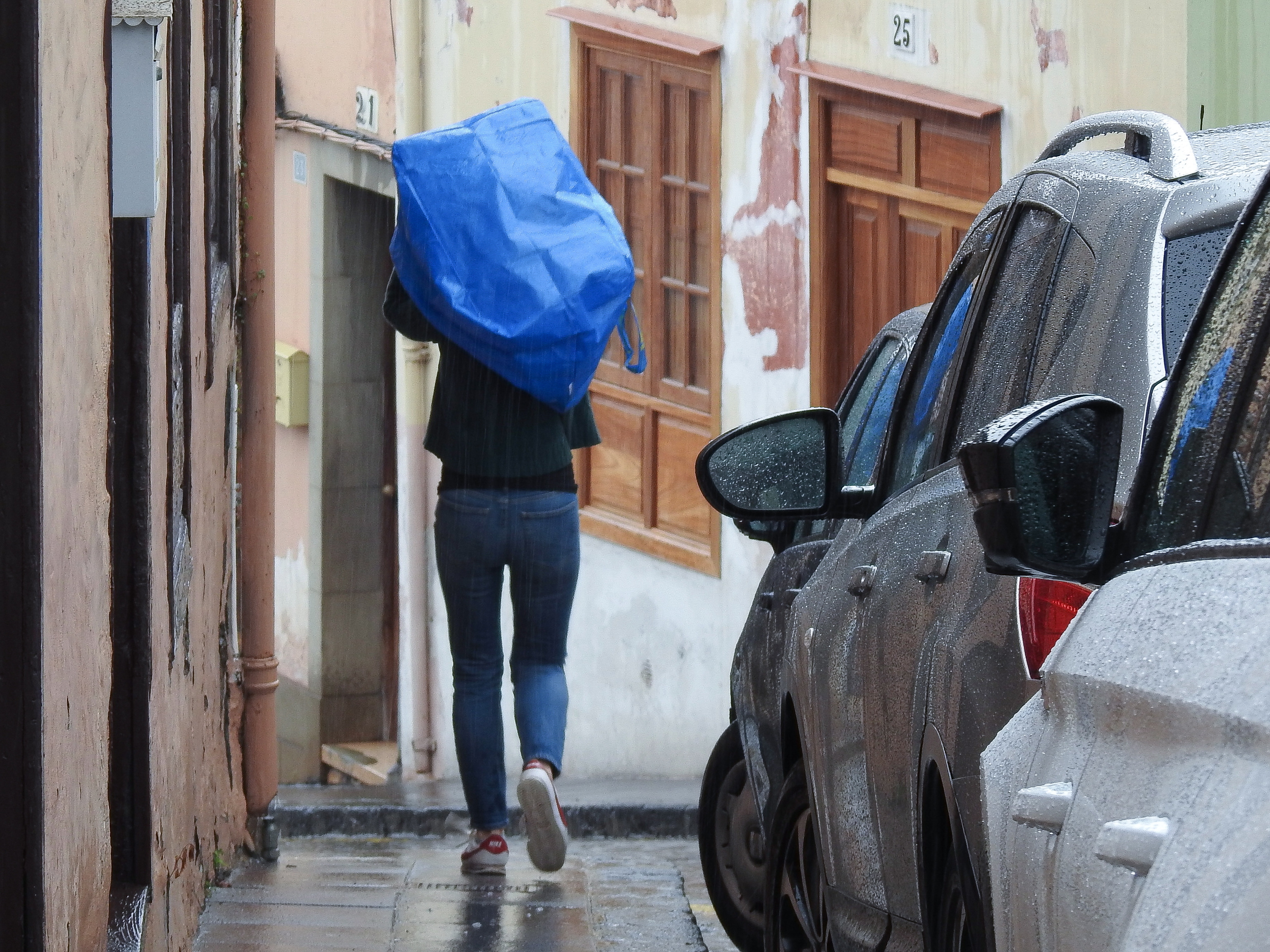 Una persona se protege de la lluvia con una bolsa de plástico durante una tormenta registrada en La Orotava, en Tenerife.