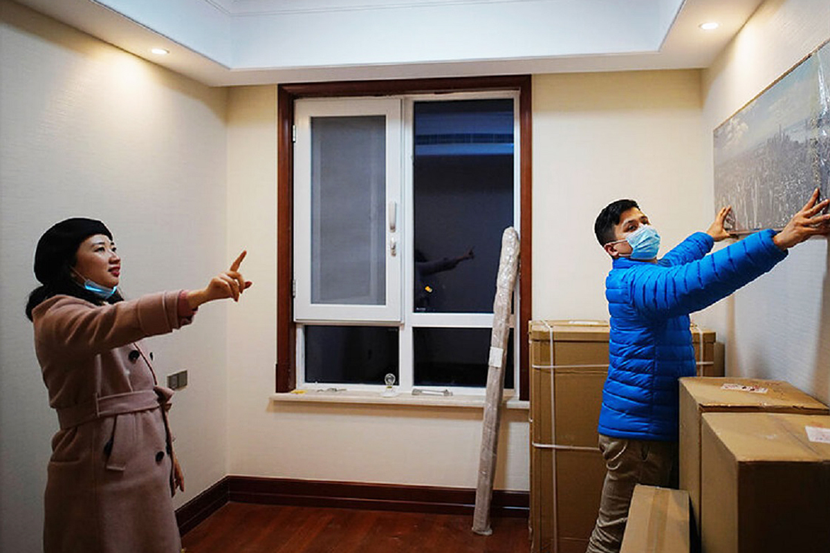 Una pareja instala un cuadro en su nuevo apartamento en Wuhan.