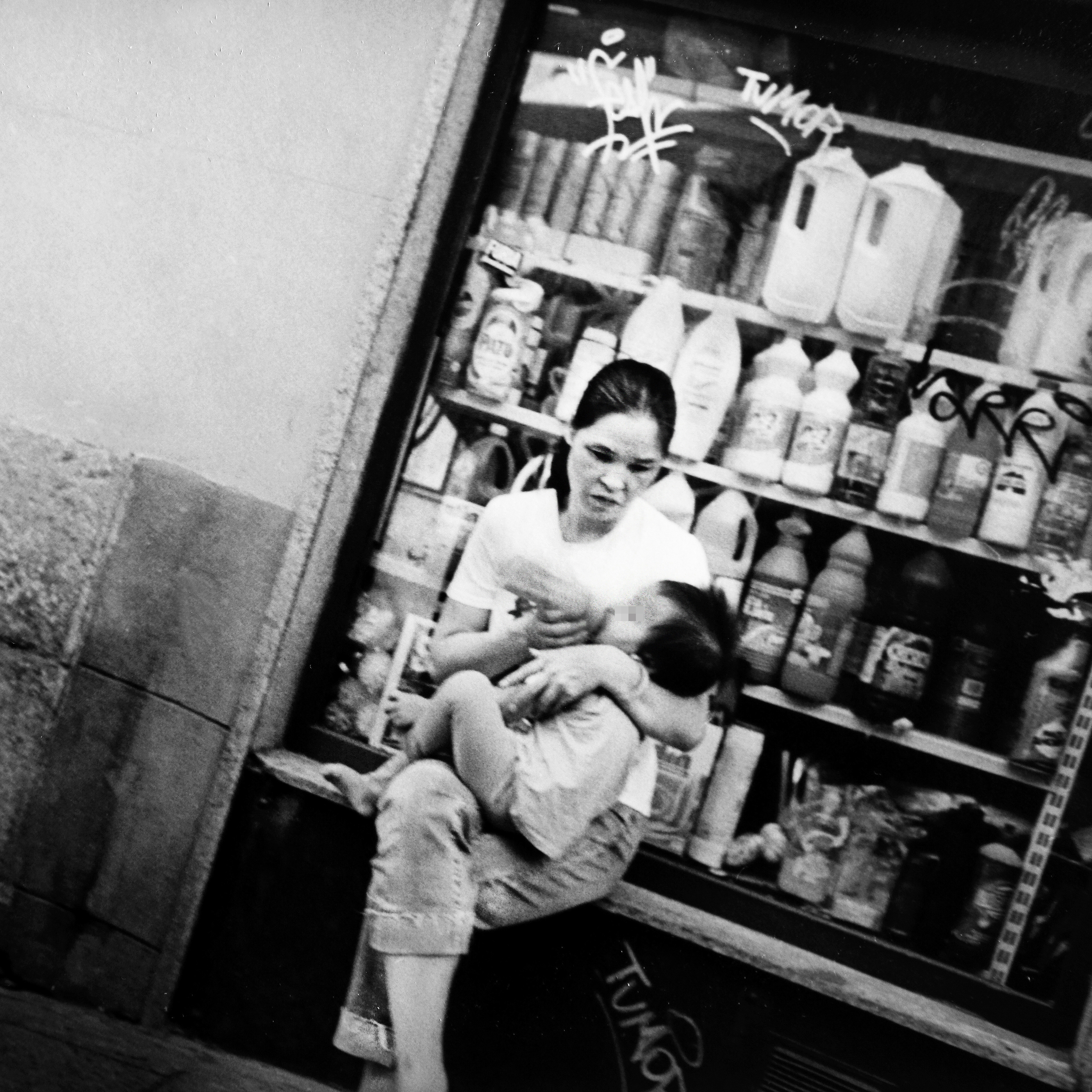 Una mujer da el bibern a su hijo en una calle del centro de Madrid.