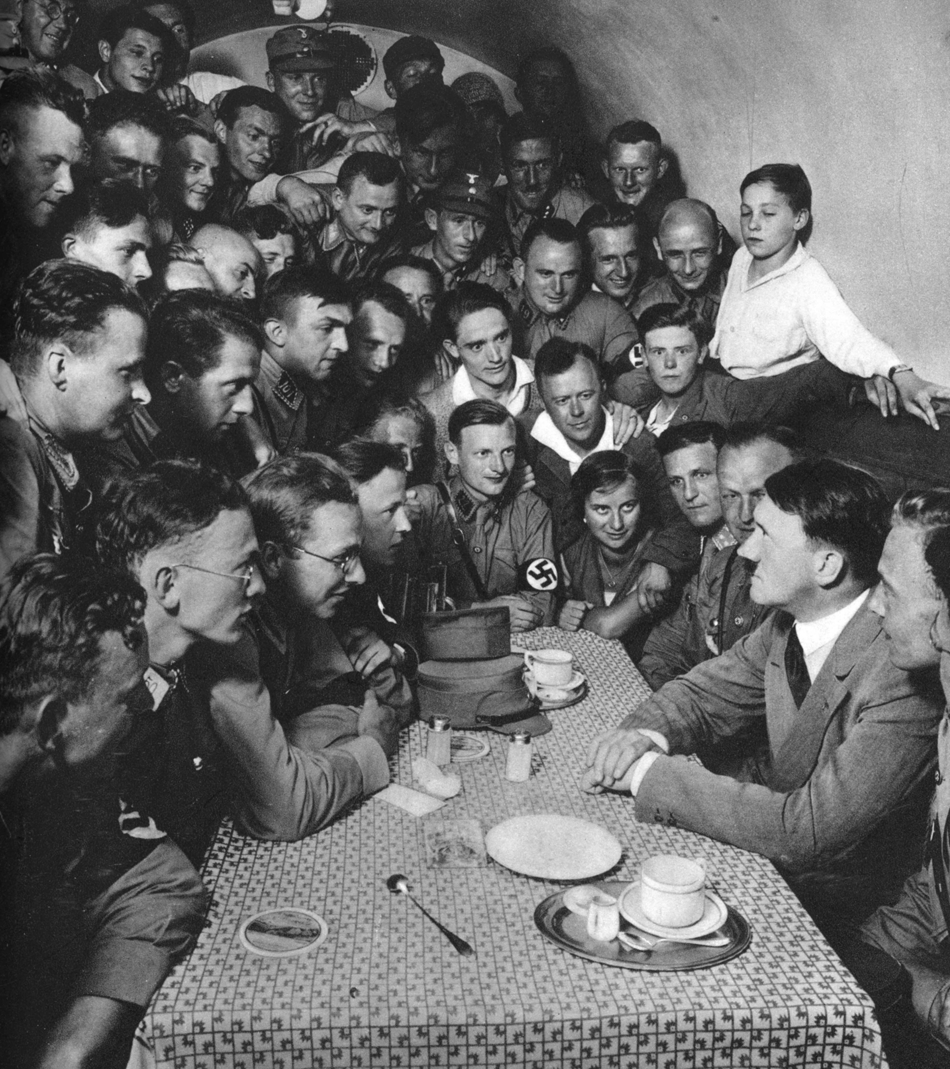 Adolf Hitler en 1933, rodeado de un grupo de personas.