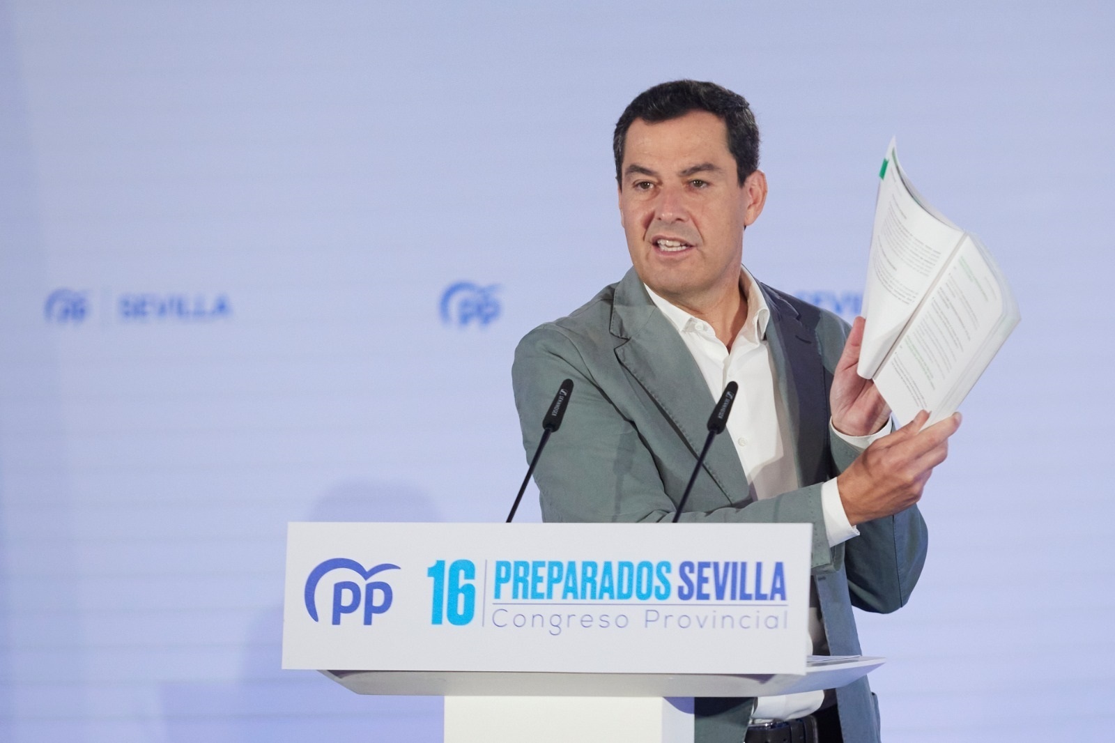 Juanma Moreno muestra el programa electoral del PP, este domingo.
