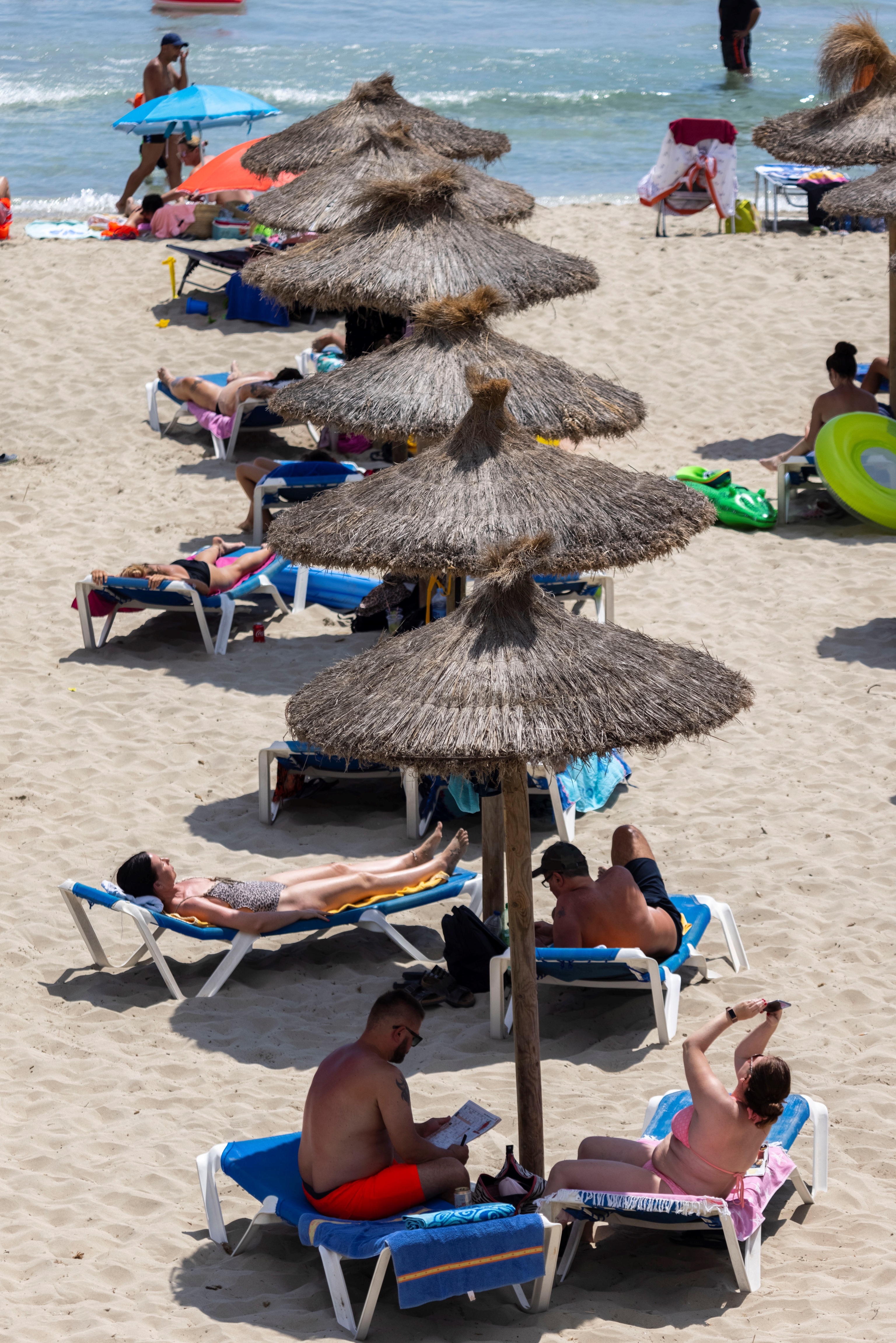 Turistas disfrutan del sol en la playa de Peguera, este jueves en el municipio mallorquín de Calvià