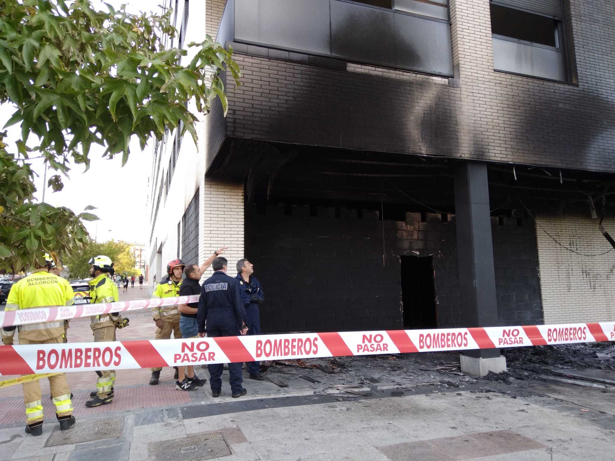 Bomberos y Polica Nacional durante el viernes por la maana en la puerta del local que ardi.