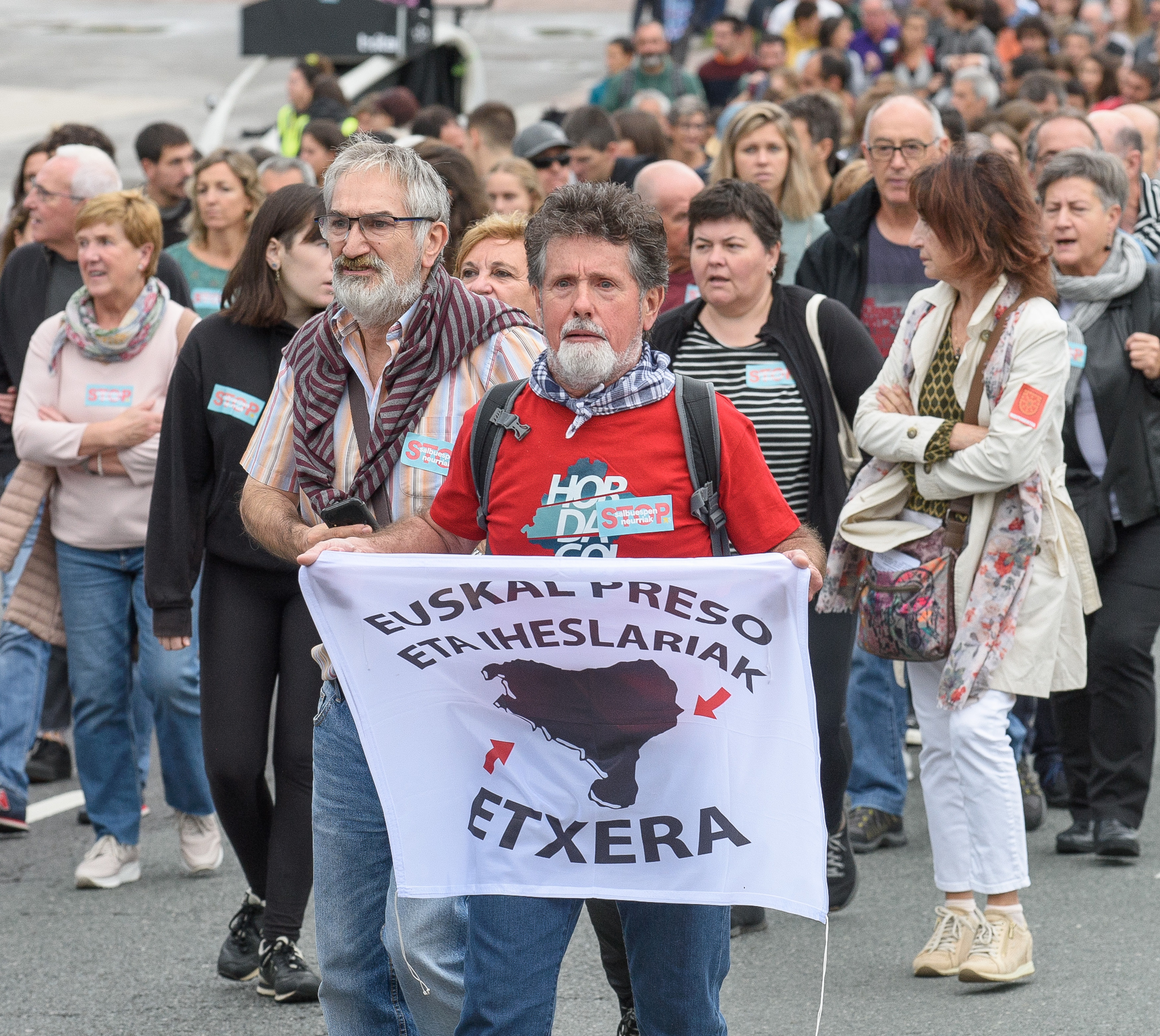 Un manifestante exhibe una pancarta que reclama la "vuelta a casa" de los presos y huidos de ETA durante una manifestacin celebrada en San Sebastin.