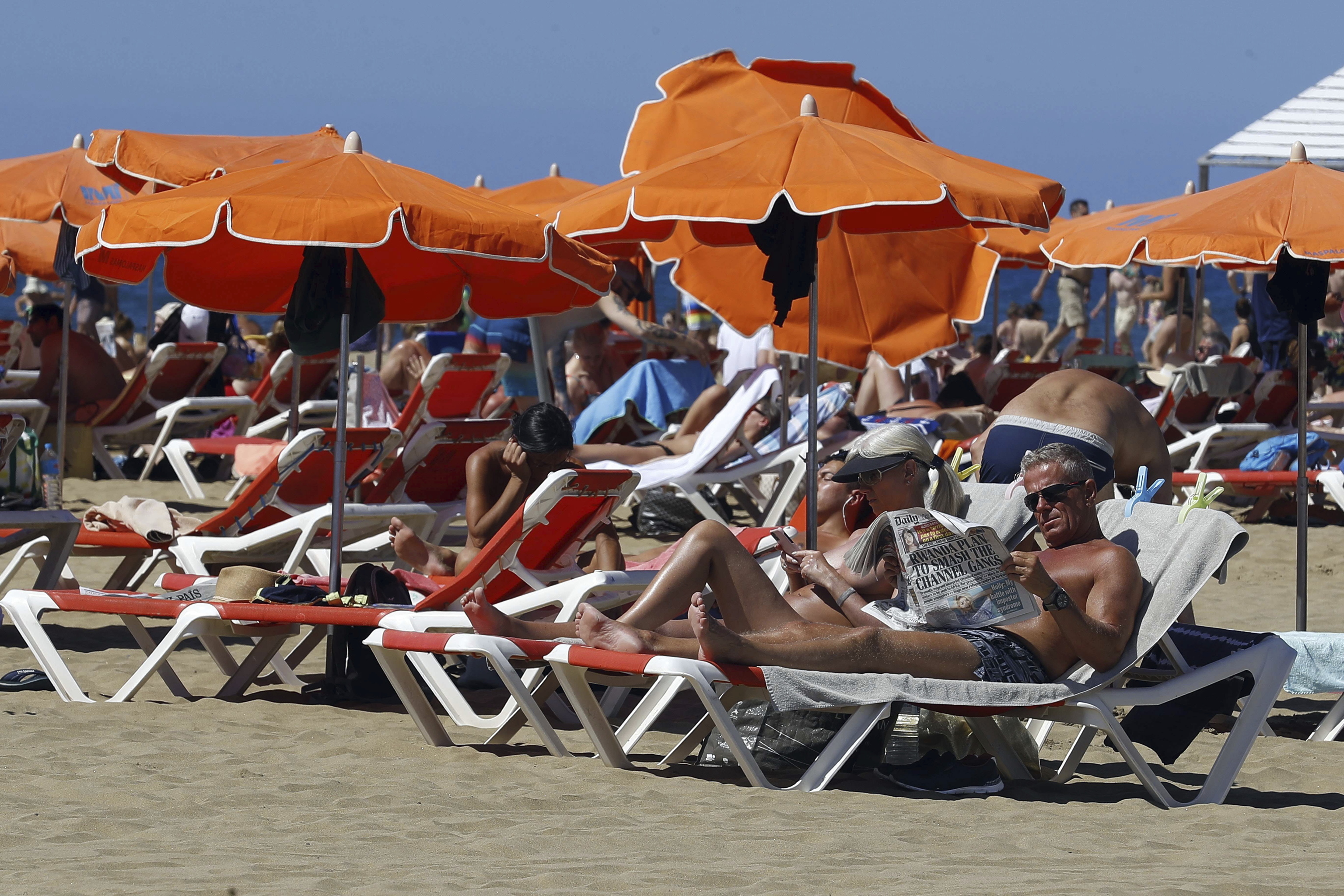 Varios turistas en una playa de Canarias.