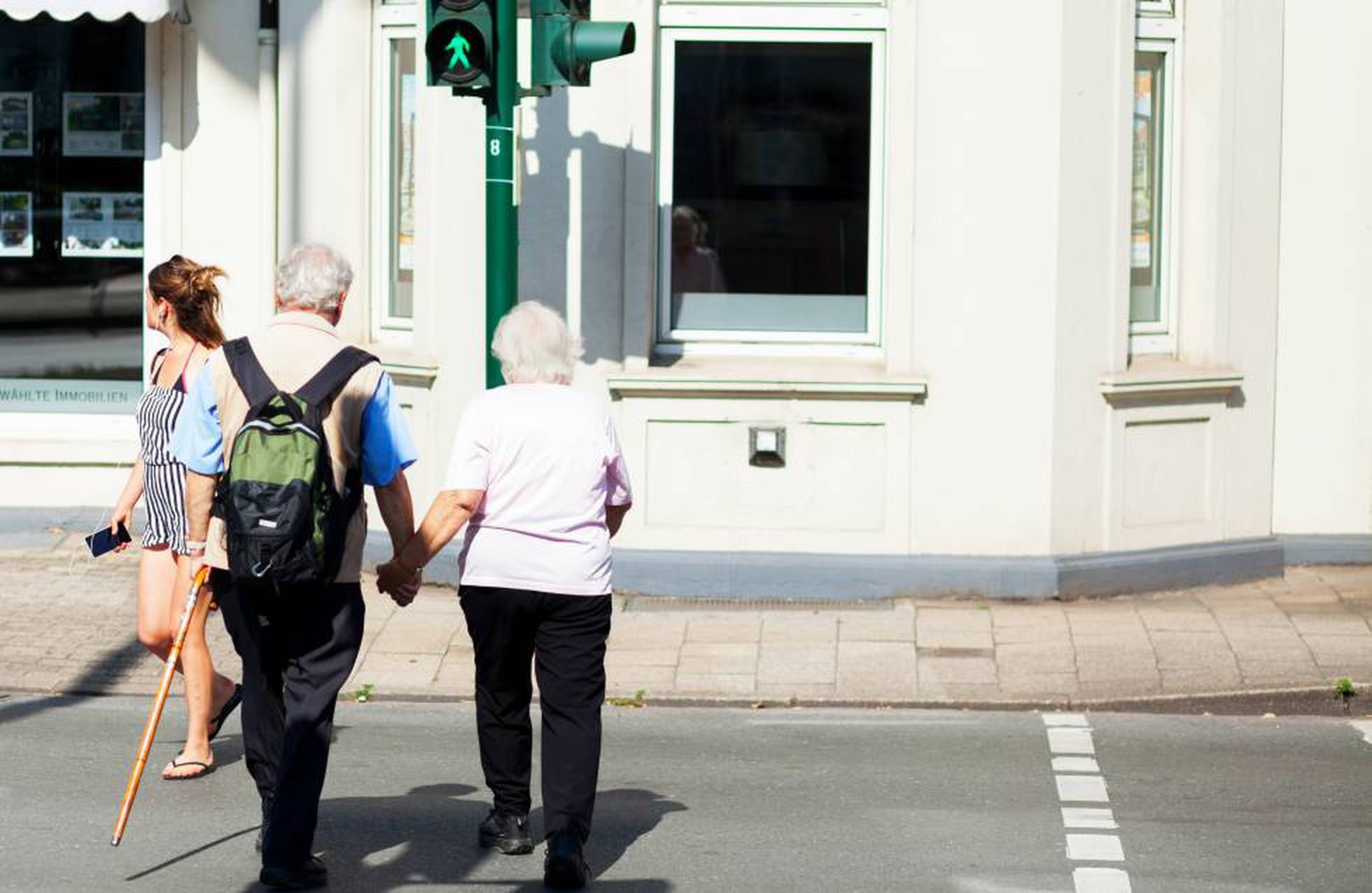 Dos personas mayores cruzan un paso de peatones