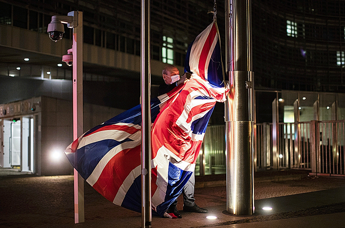 Un trabajador coloca la bandera del Reino Unido en Bruselas antes de una reunión.