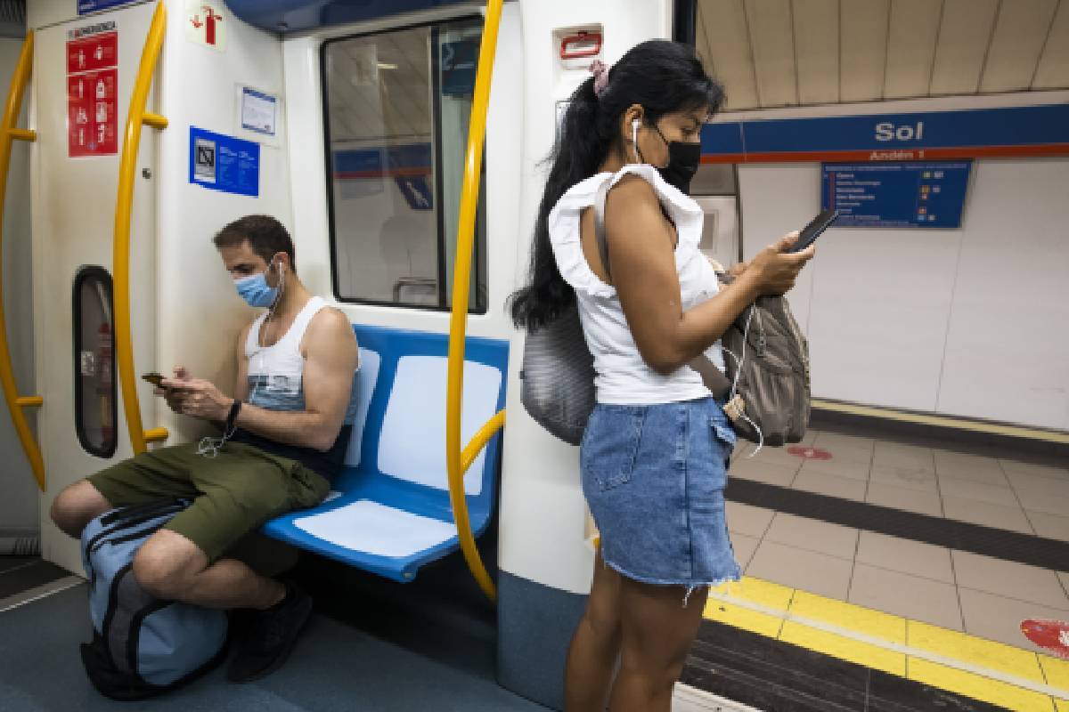 Dos personas miran el móvil en el metro