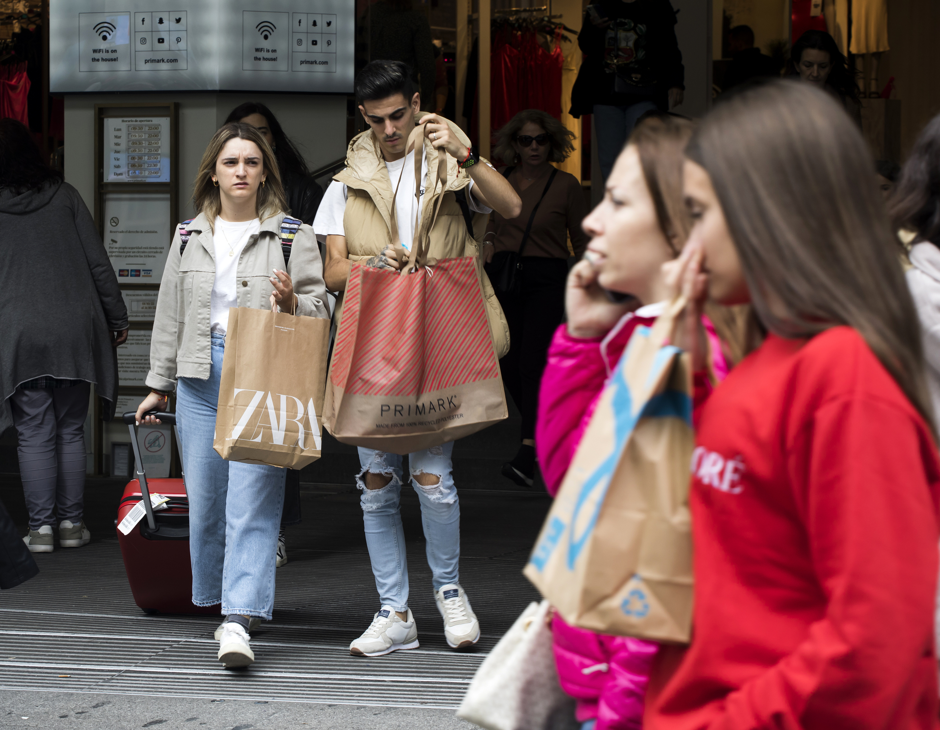 Gente con bolsas tras comprar en las tiendas del centro de Madrid.