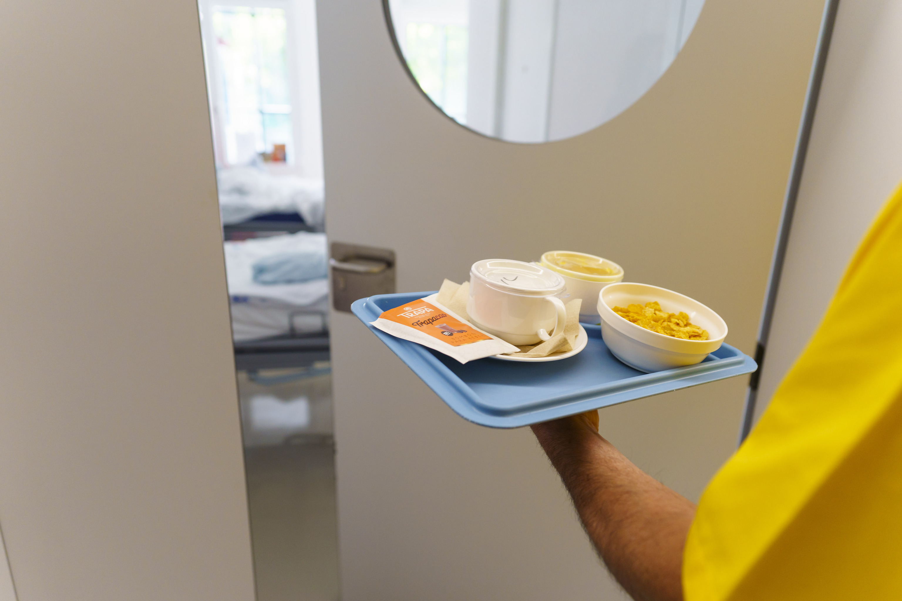 Un sanitario porta una bandeja con comida en la unidad de psiquiatra del Nio Jess