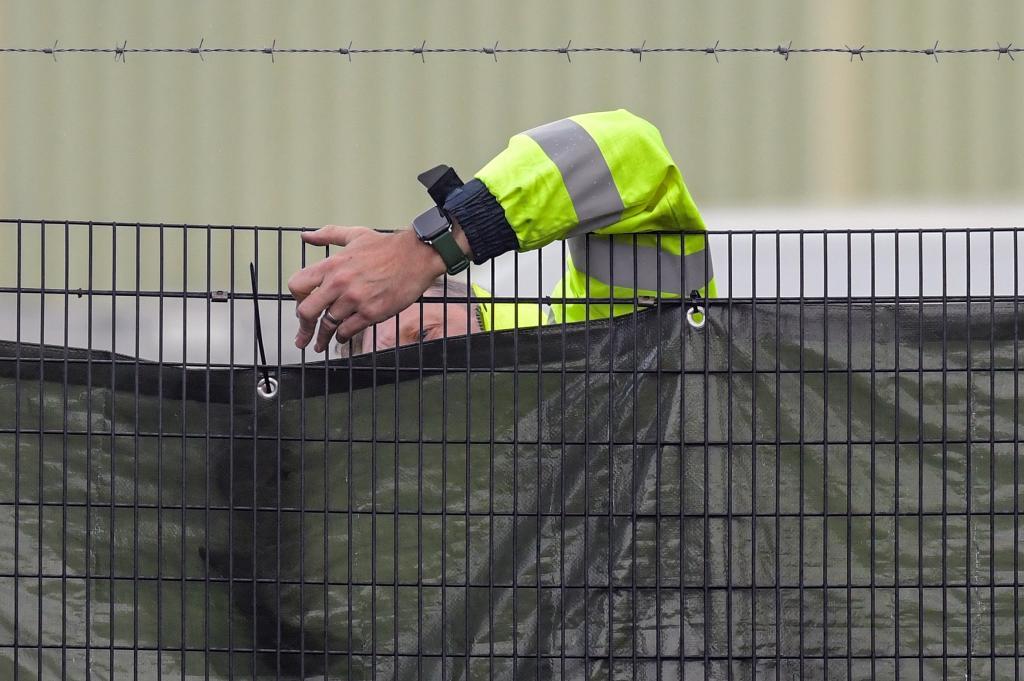 Un guardia de seguridad asegura una valla exterior del centro de inmigración de Manston.
