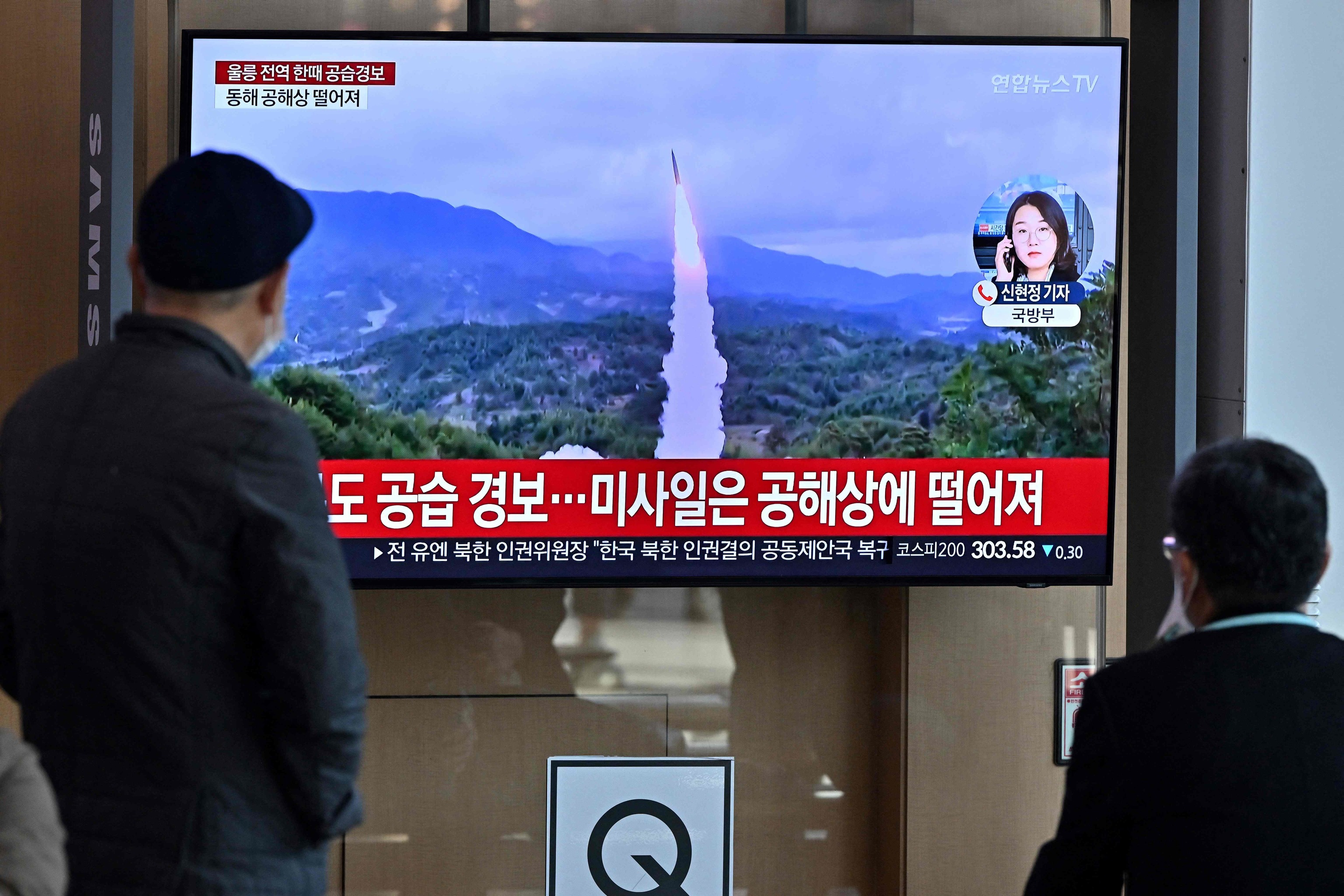 Coreanos miran una pantalla de televisin que muestra una transmisin de noticias con imgenes de archivo de una prueba de misiles de Corea del Norte, en una estacin de tren en Sel.