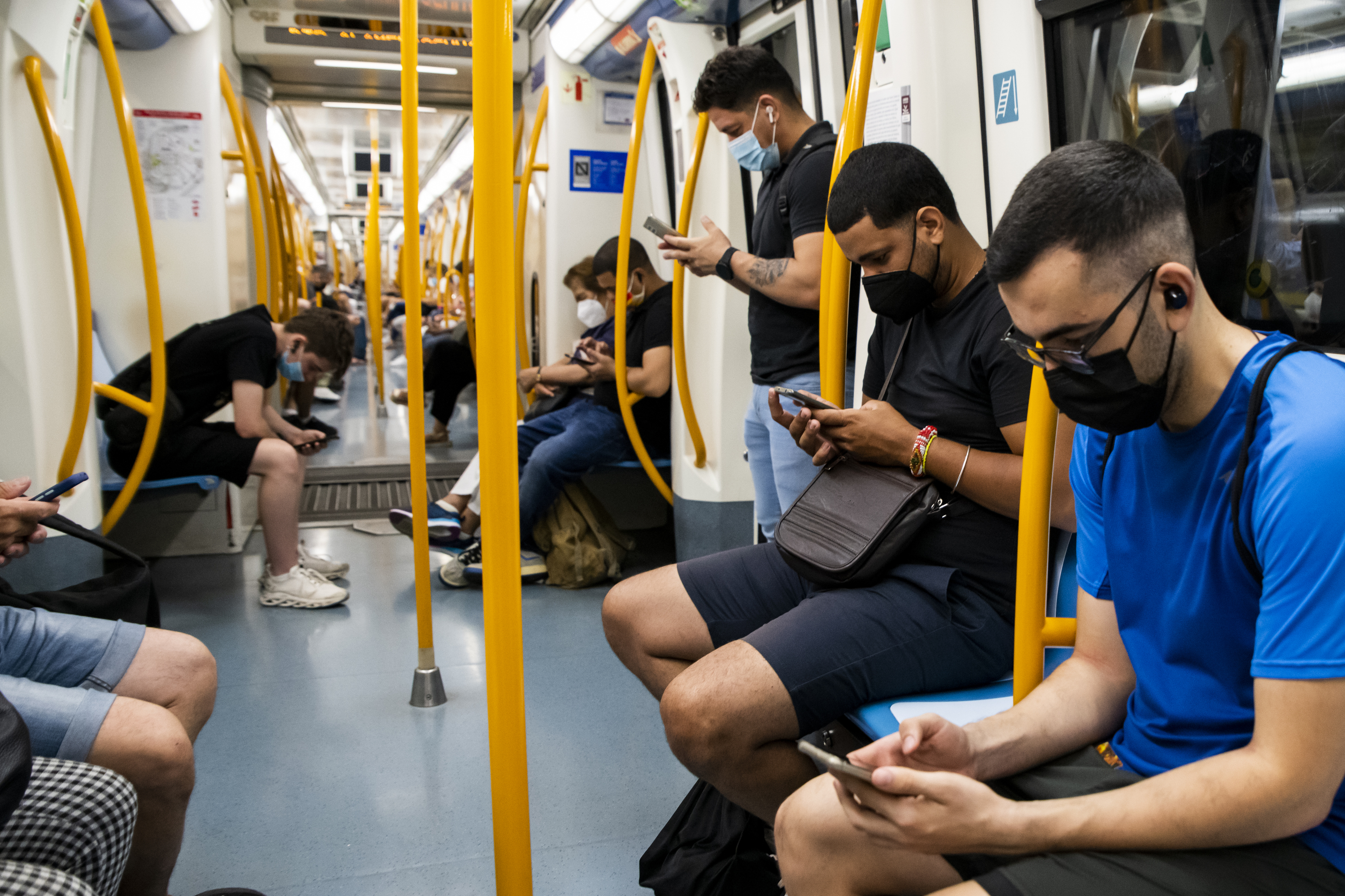 Usuarios del Metro de Madrid con su teléfono móvil.