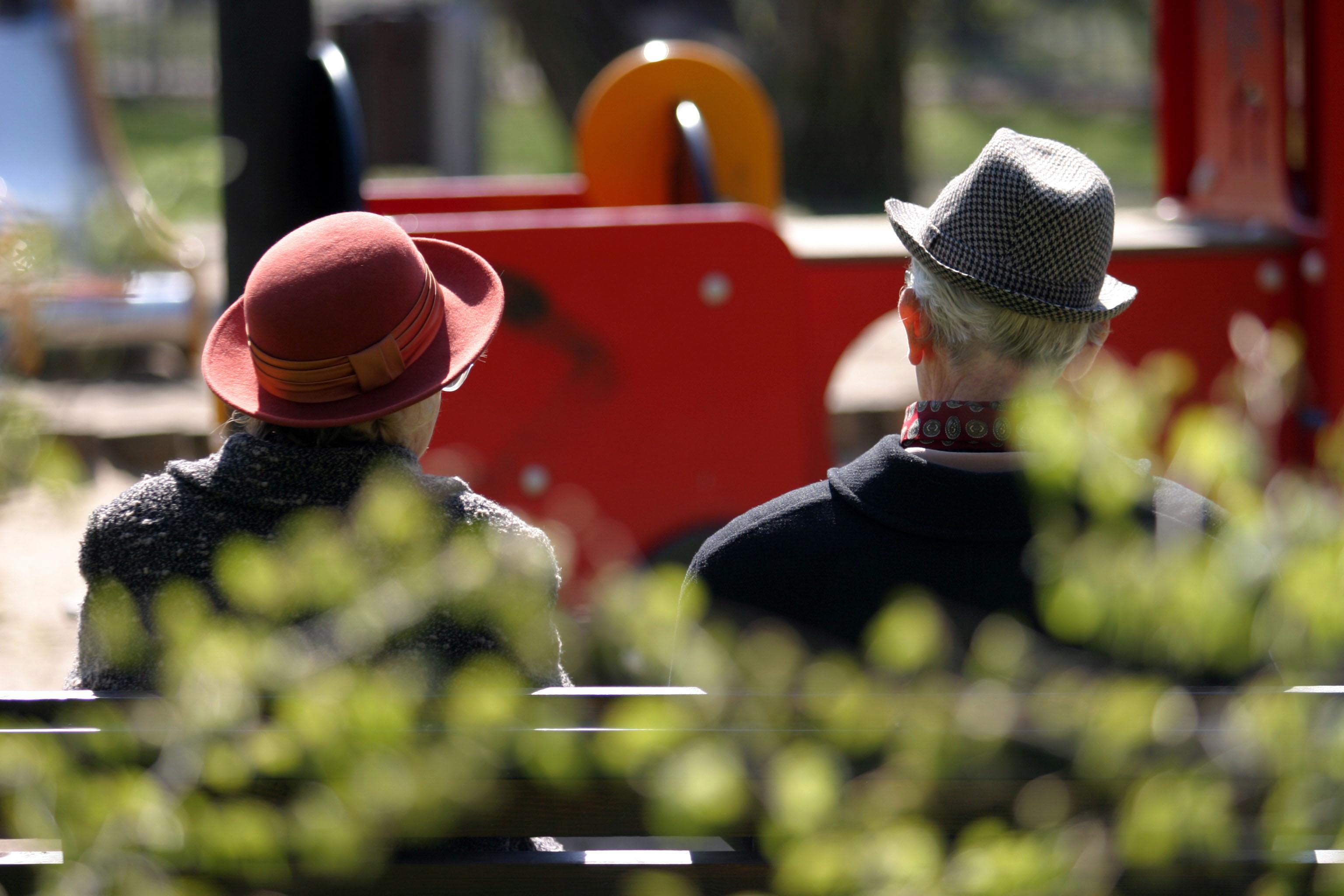Dos jubilados sentados en un banco de un parque de Madrid.