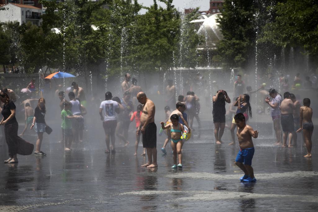 Varias personas bajo chorros de agua en Madrid el pasado agosto durante la ola de calor.