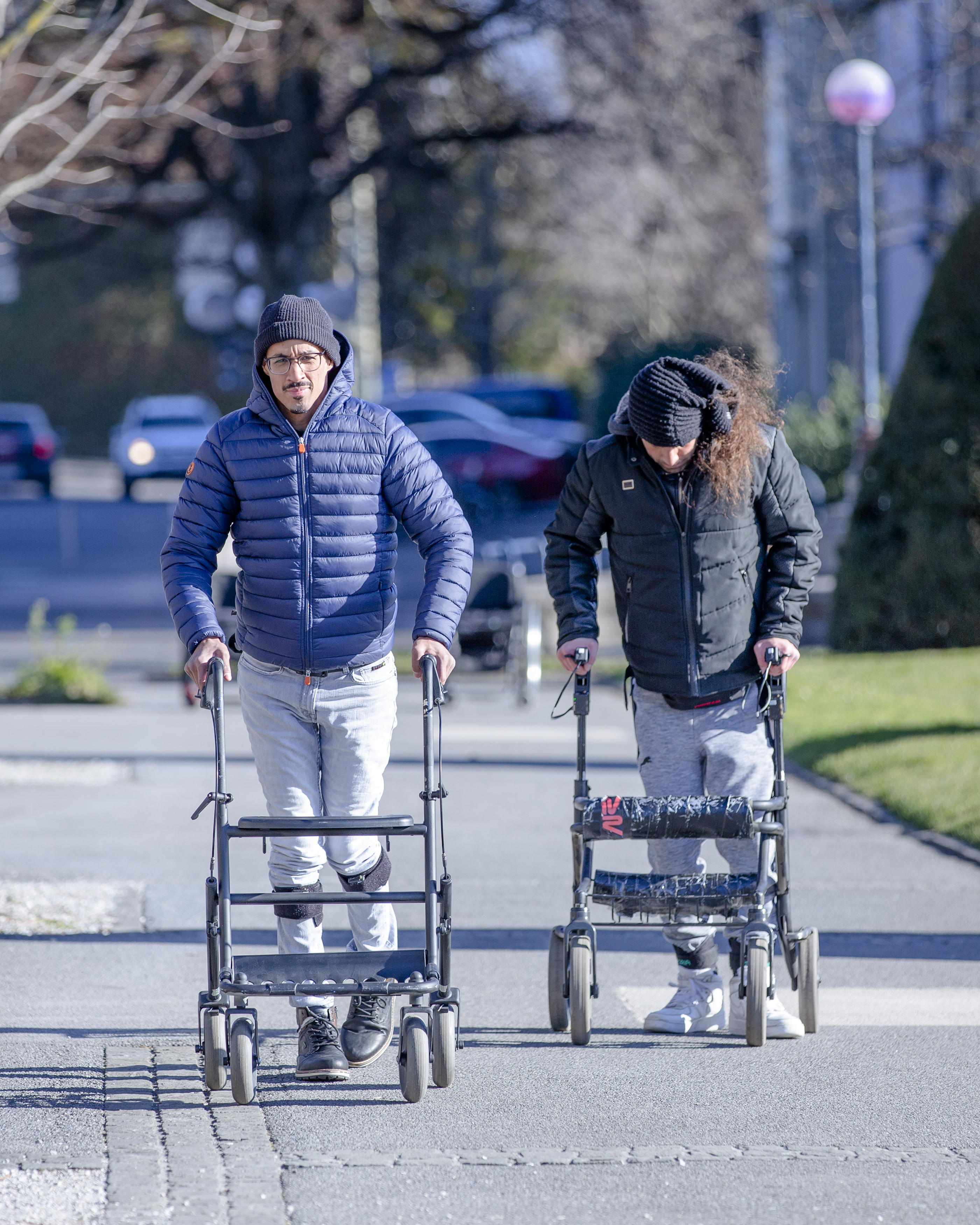 Dos pacientes caminando con ayuda de un andador.