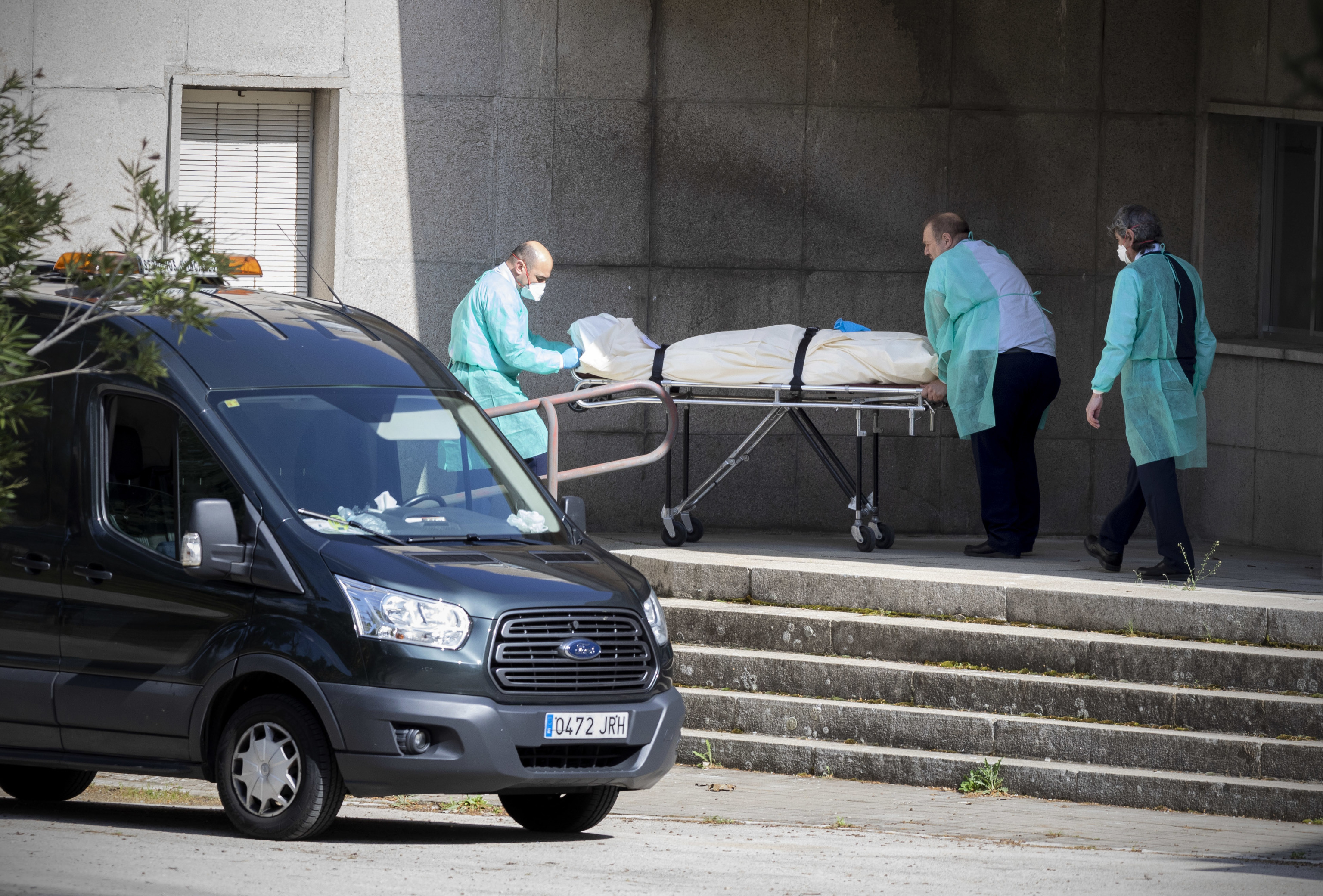 Operarios de una funeraria trasladan un cadáver en una residencia durante la primera ola de covid de 2020.