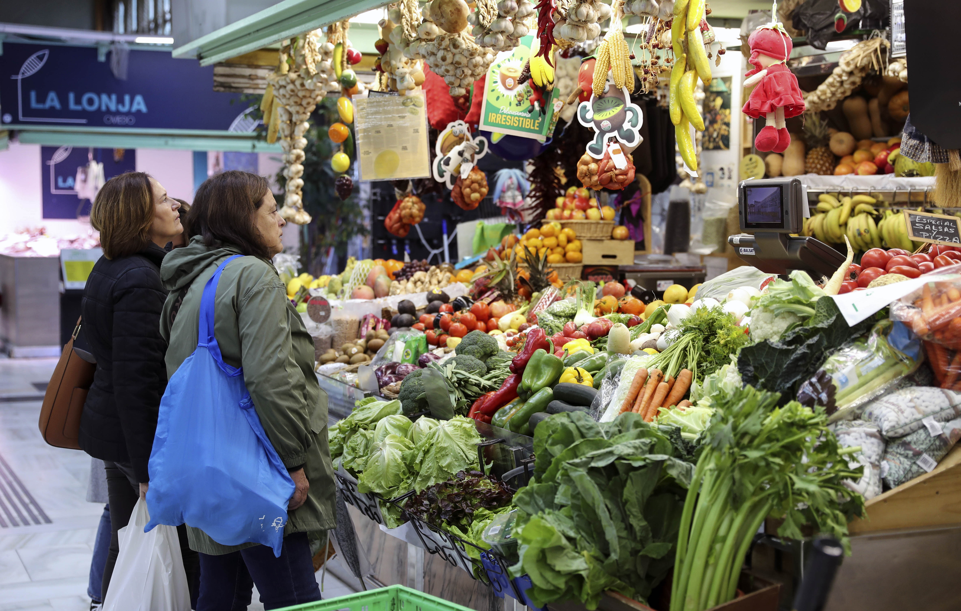 Varias personas hacen la compra en un mercado de El Fontn de Oviedo este martes.