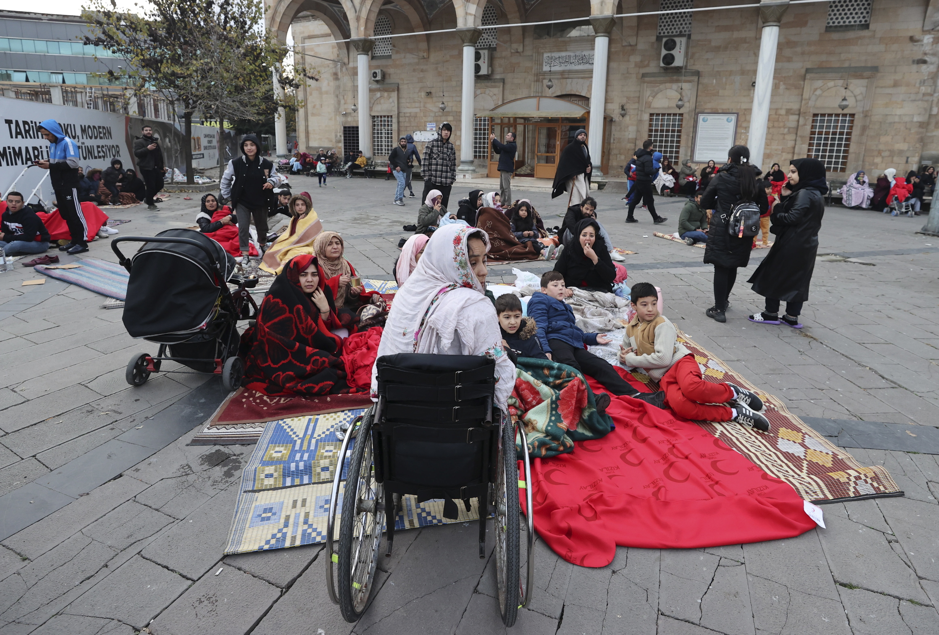 Varias personas con mantas en la calle en Duzce ante el temor a nuevos terremotos.