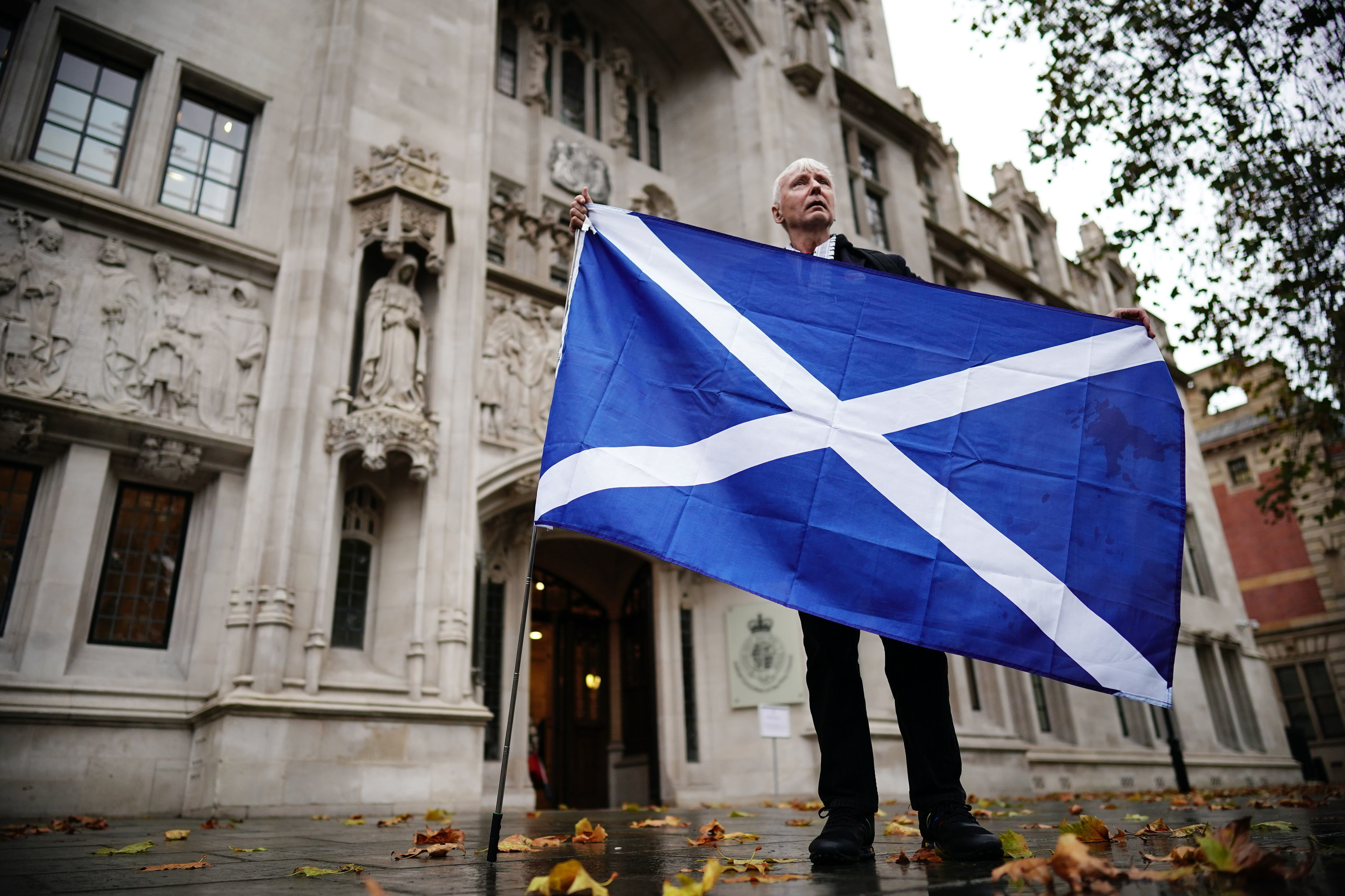 Un partidario de la independencia sujeta una bandera escocesa frente al Supremo, en Londres.