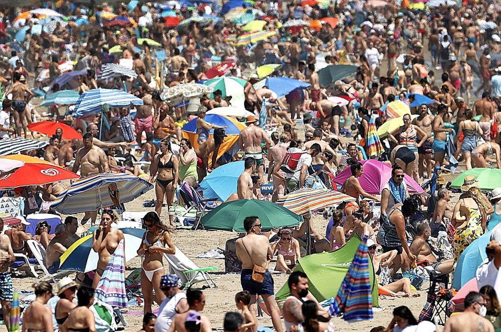 Miles de personas en la playa valenciana de la Malvarrosa.