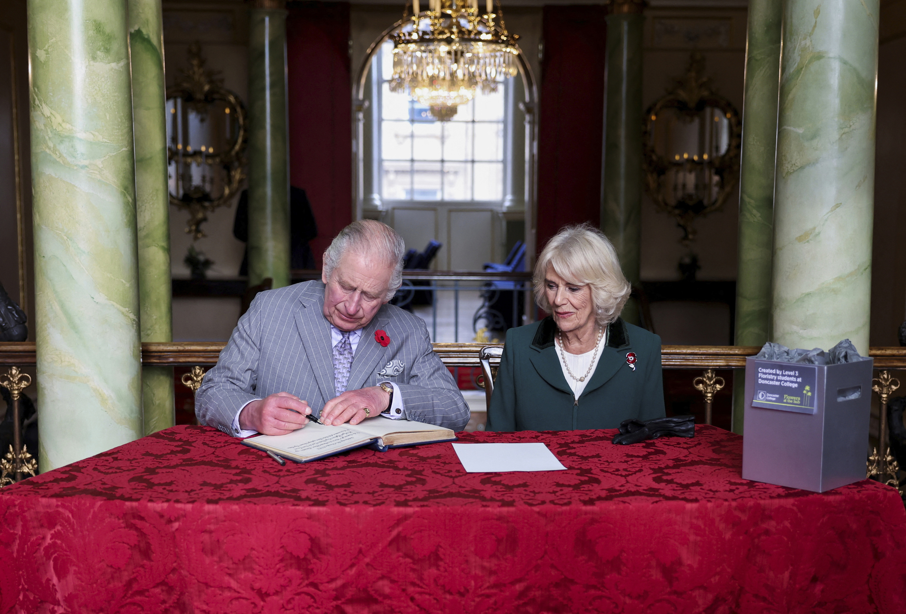 Los reyes Carlos y Camila firman en el libro de honor durante su visita a Doncaster (Inglaterra).