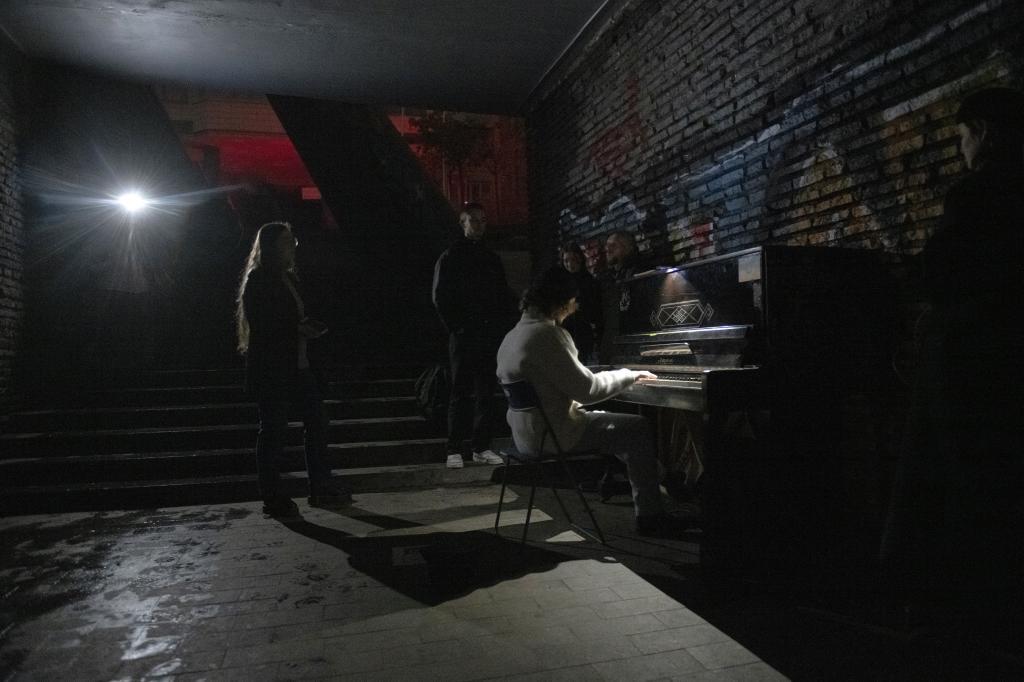 Una mujer toca el piano a oscuras en Kiev.