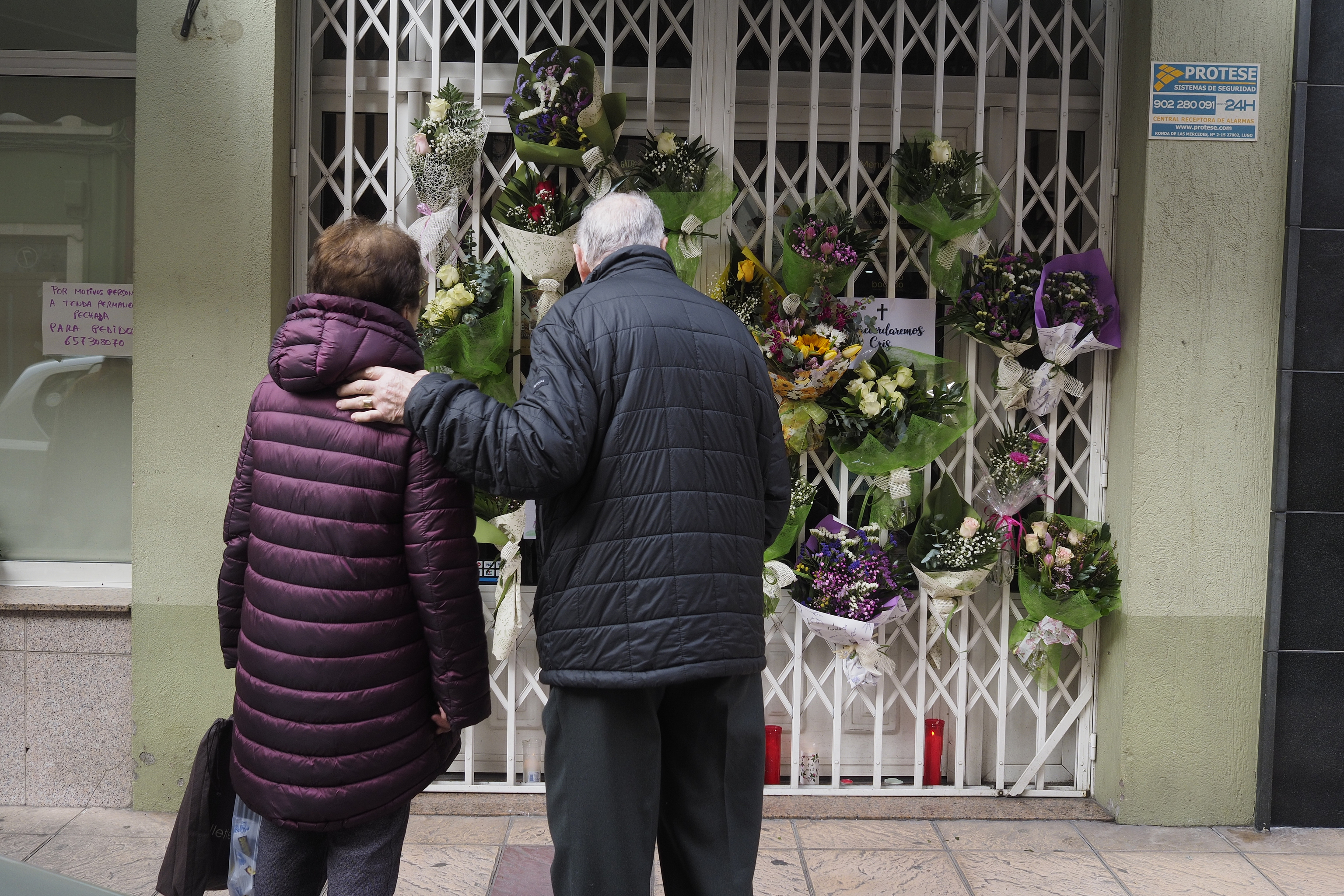 Vecinos de Lugo dejan ramos en flores en la tienda que regentaba la mujer asesinada.