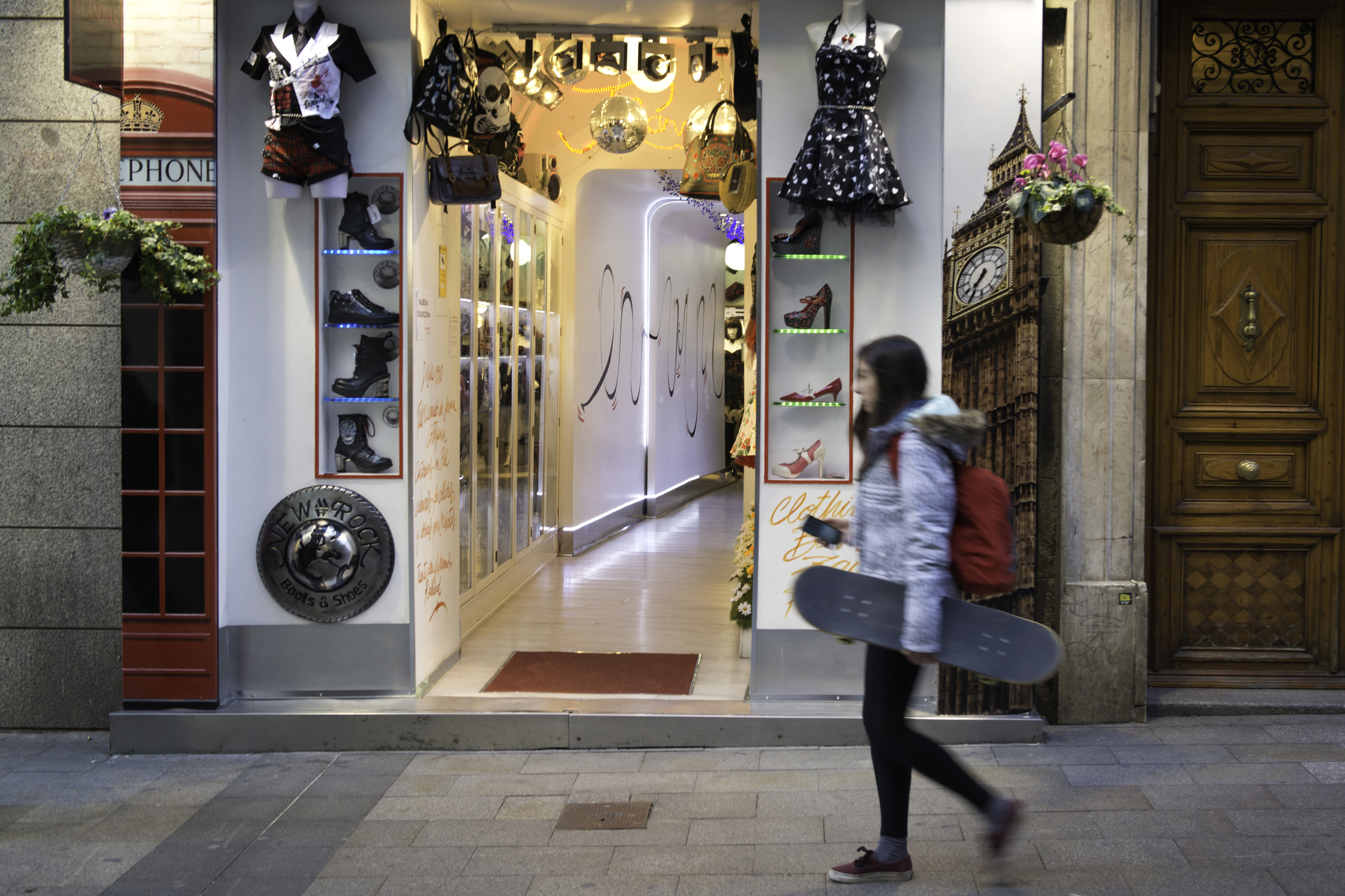 Una joven pase entra las tiendas de la calle de Fuencarral.