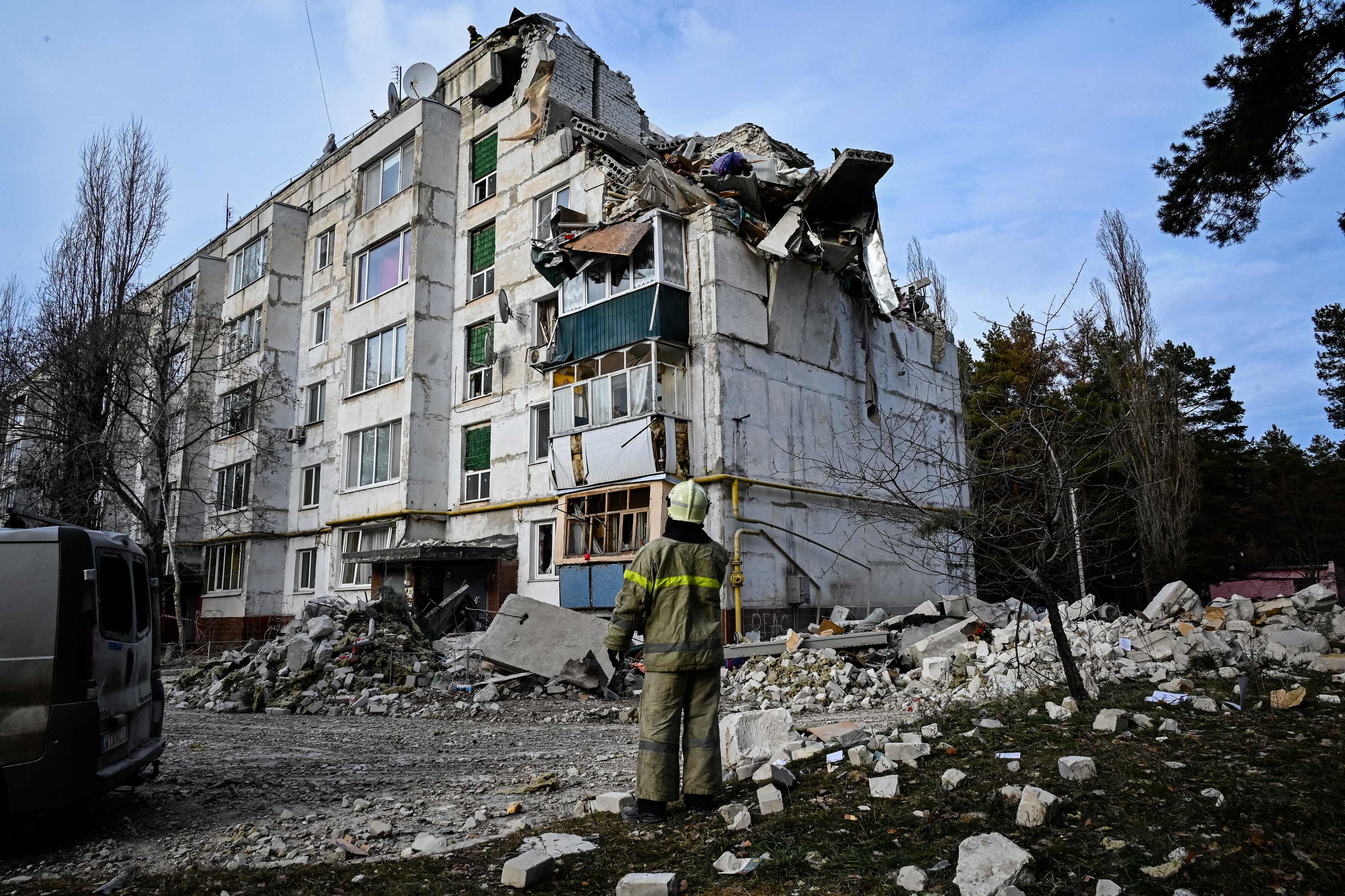 Un bombero mira hacia un edificio destrozado por un misil en Kluhyno-Bashkyrivka (Jarkov).