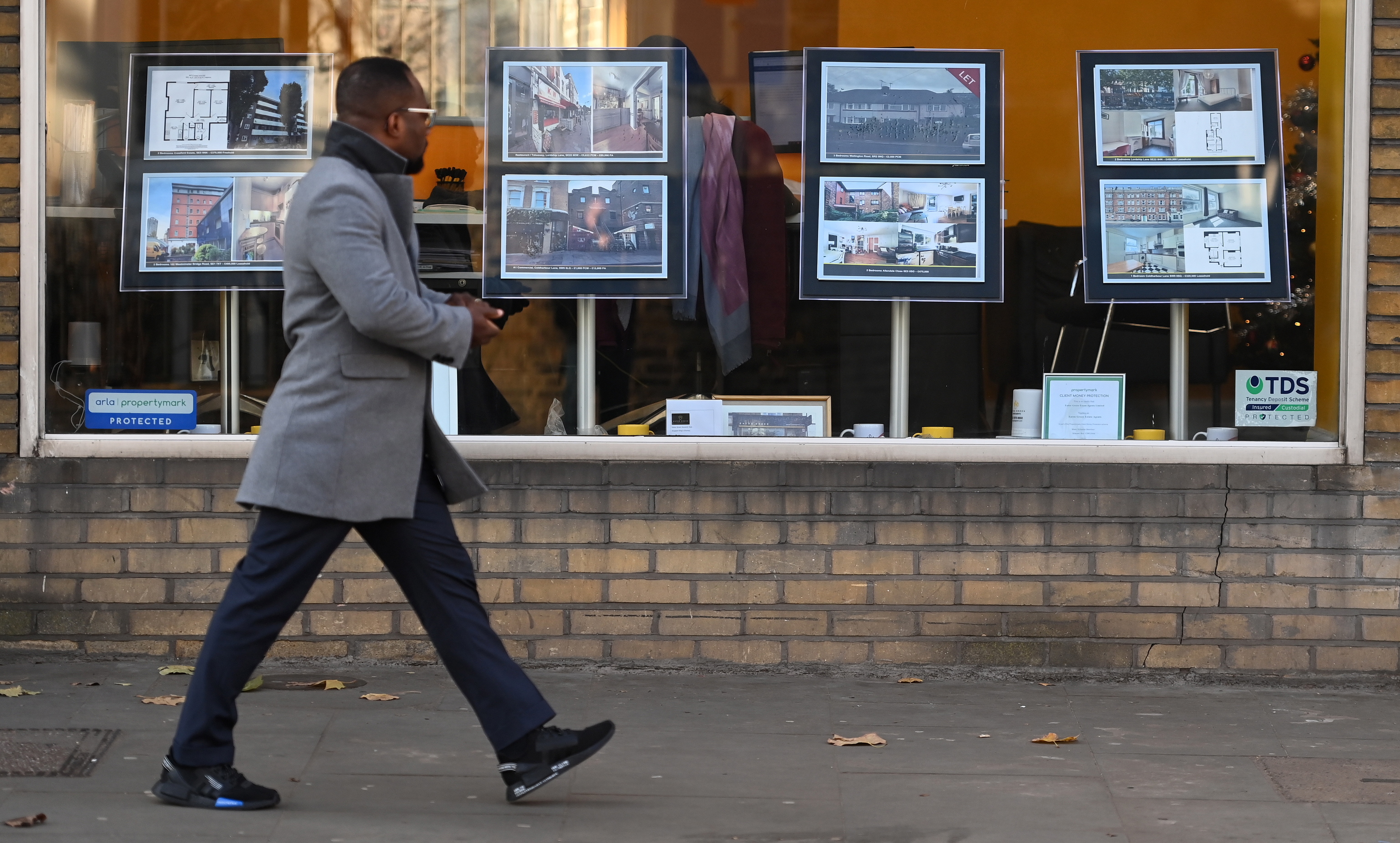 Un hombre pasa por delante de una agencia inmobiliaria en Londres