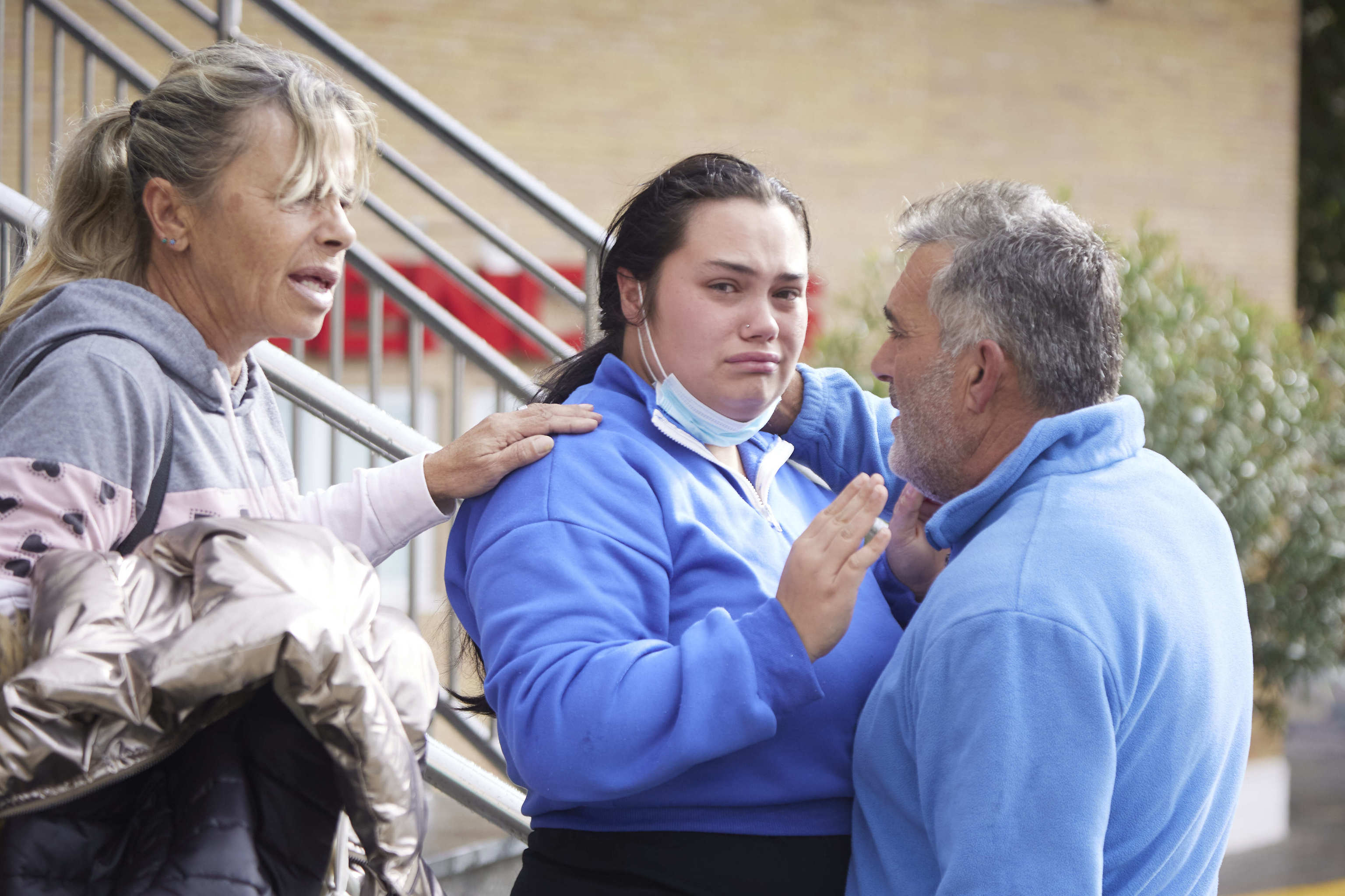 La madre del menor, llora desconsolada, junto a sus padres en la puerta del Infantil del Hospital Virgen del Roco.