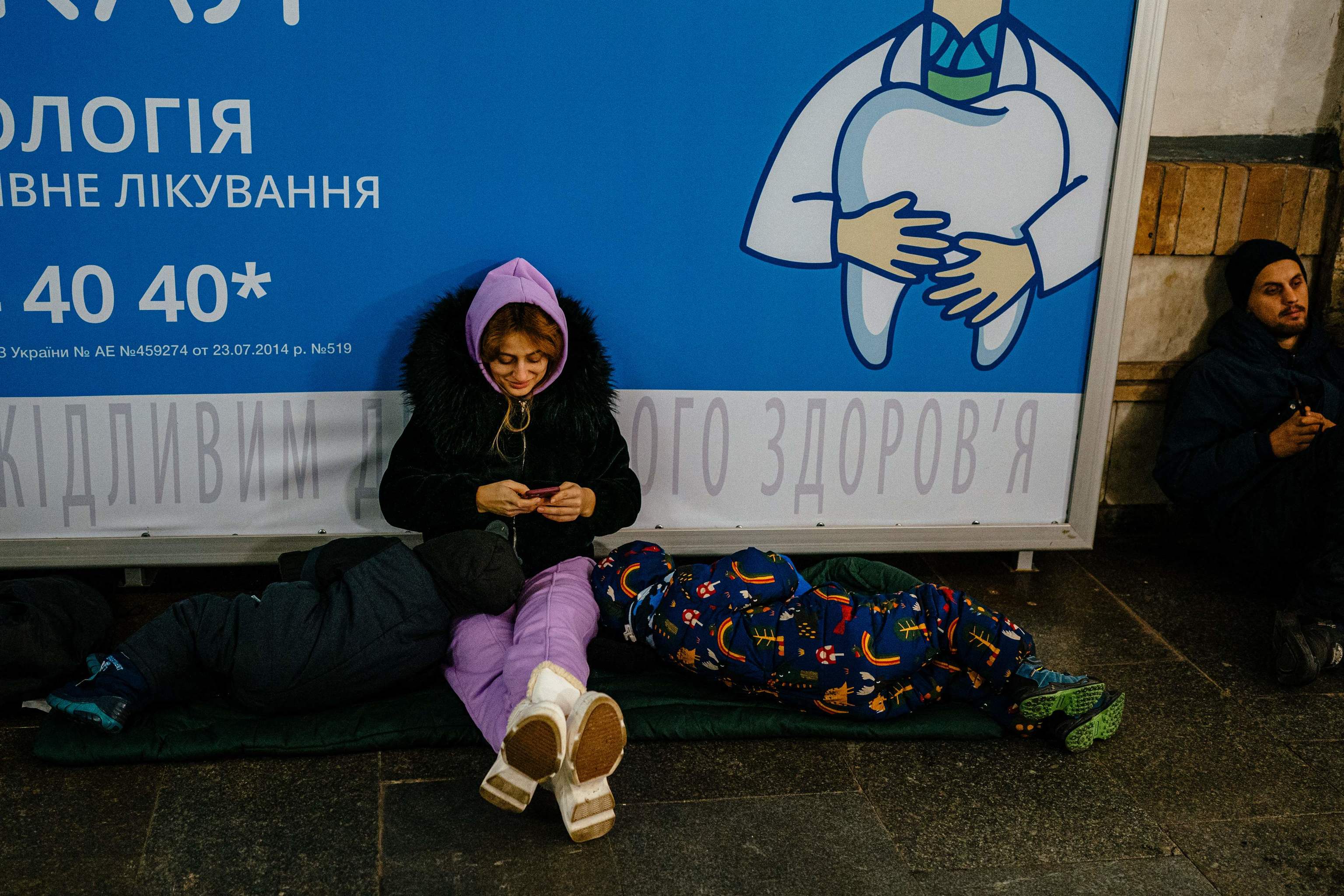 Una mujer y sus dos hijos se refugian en el interior de una estacin de metro durante una alerta antiarea en el centro de Kiev el 14 de diciembre de 2022, en medio de la invasin rusa de Ucrania. - El 14 de diciembre se escucharon explosiones en un barrio cntrico de la capital ucraniana, Kiev, segn declar el alcalde Vitali Klitschko, tras lo que parece haber sido un ataque con drones.