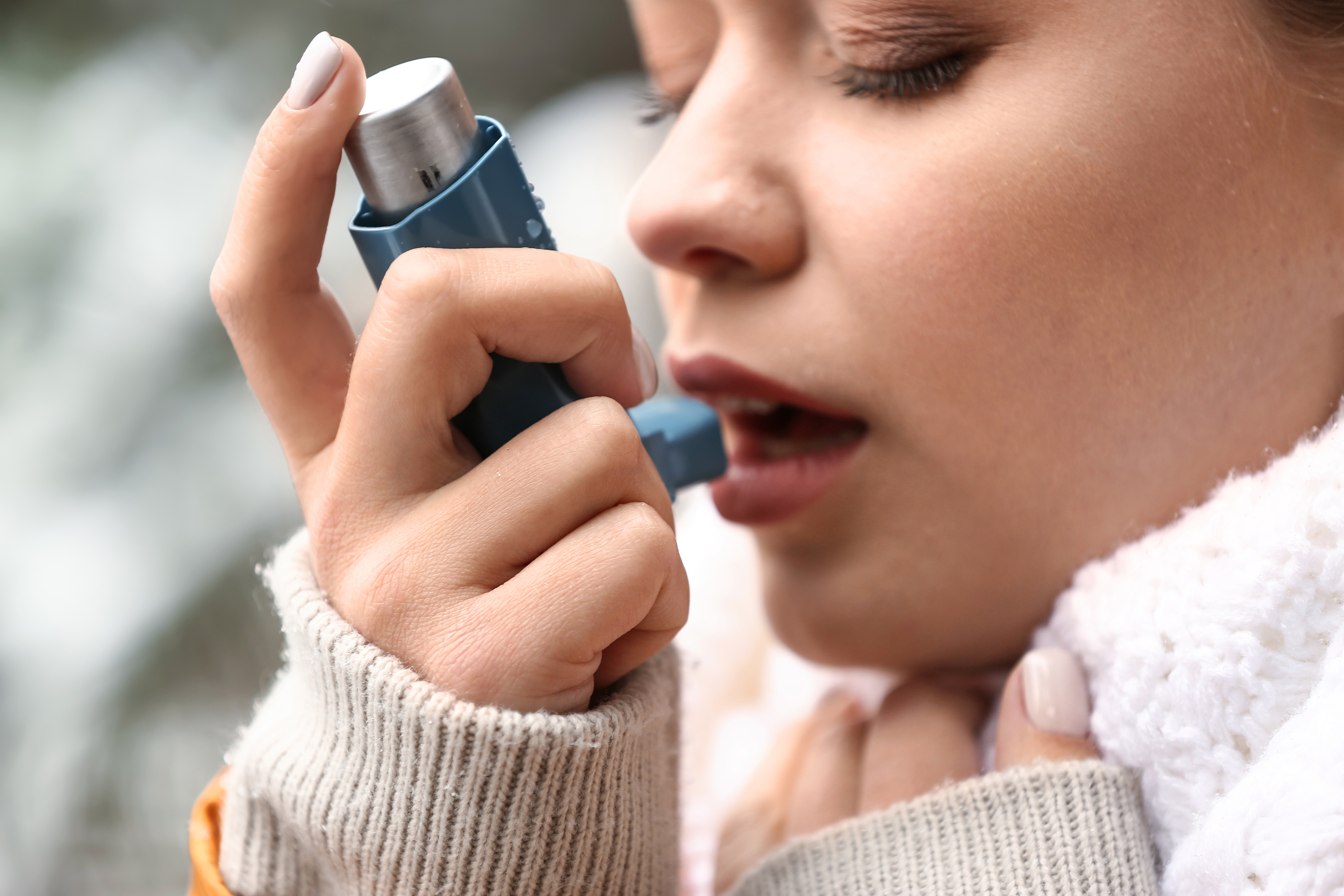 Una mujer con un inhalador para el asma.