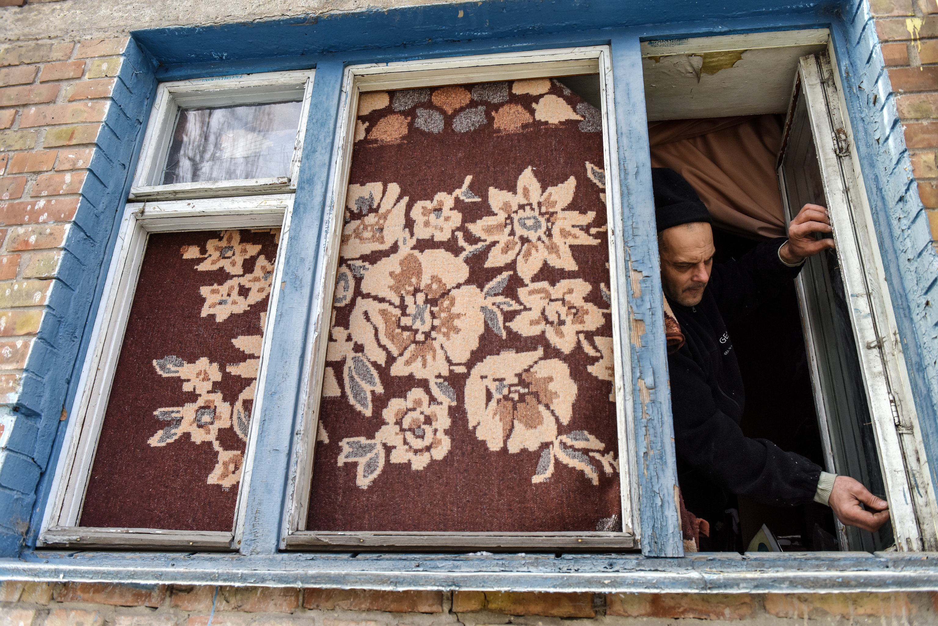 Un kievita arregla su ventana después de que los drones rusos sobre Kiev hicieran estallar los cristales de su casa.