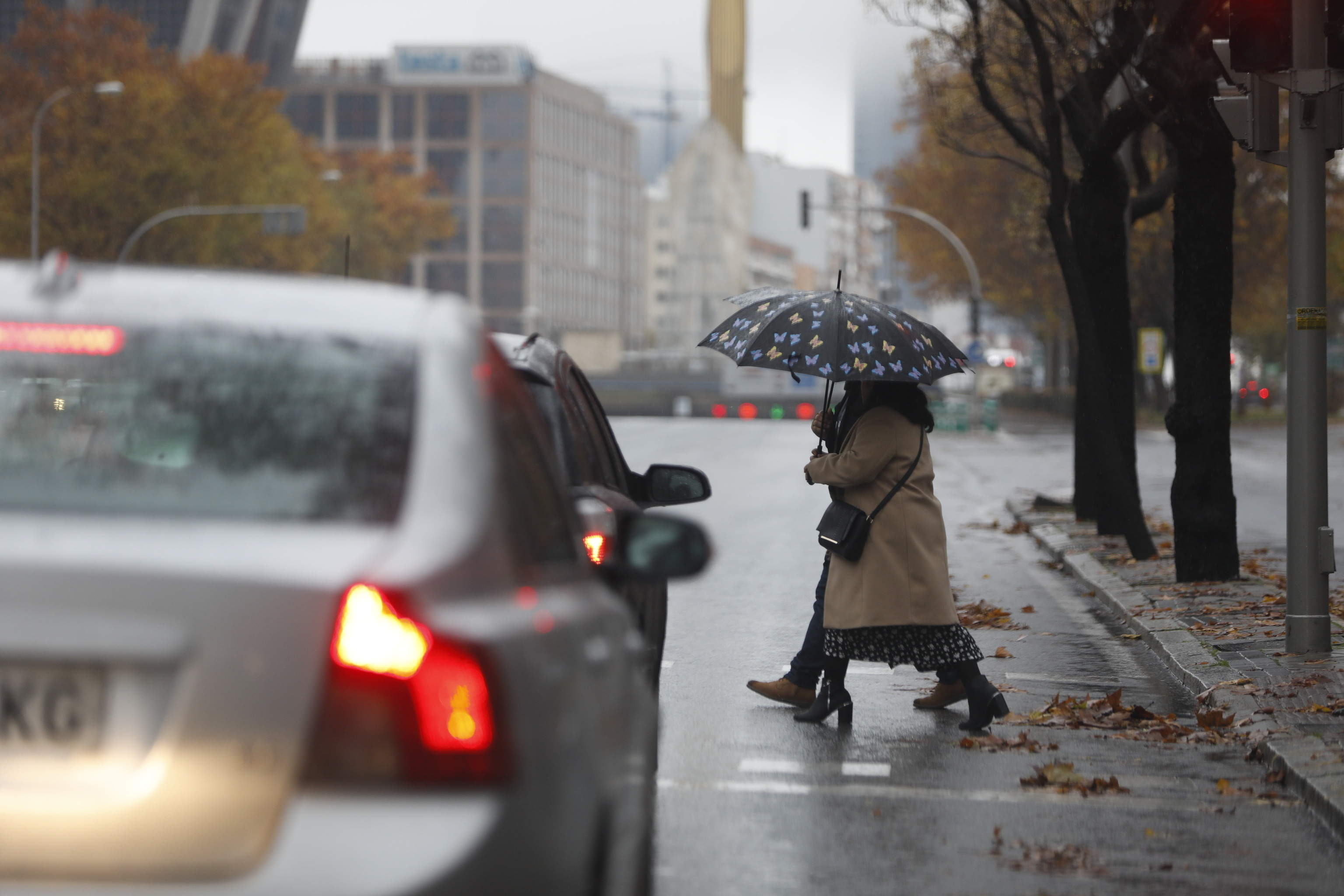 Dos personas cruzan una calle en Madrid en un da lluvioso.