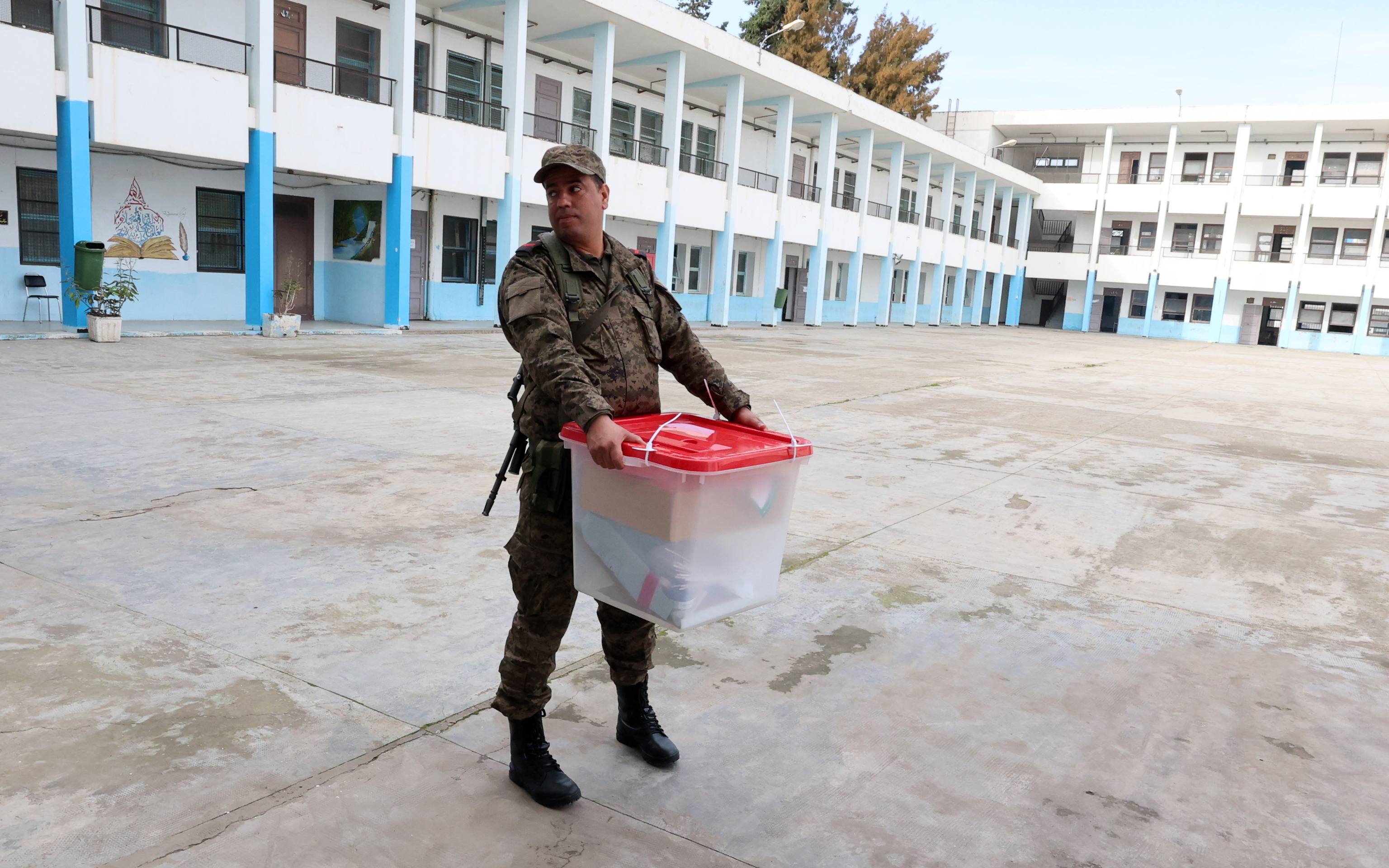 Un soldado traslada una urna a un colegio electoral de Tnez.