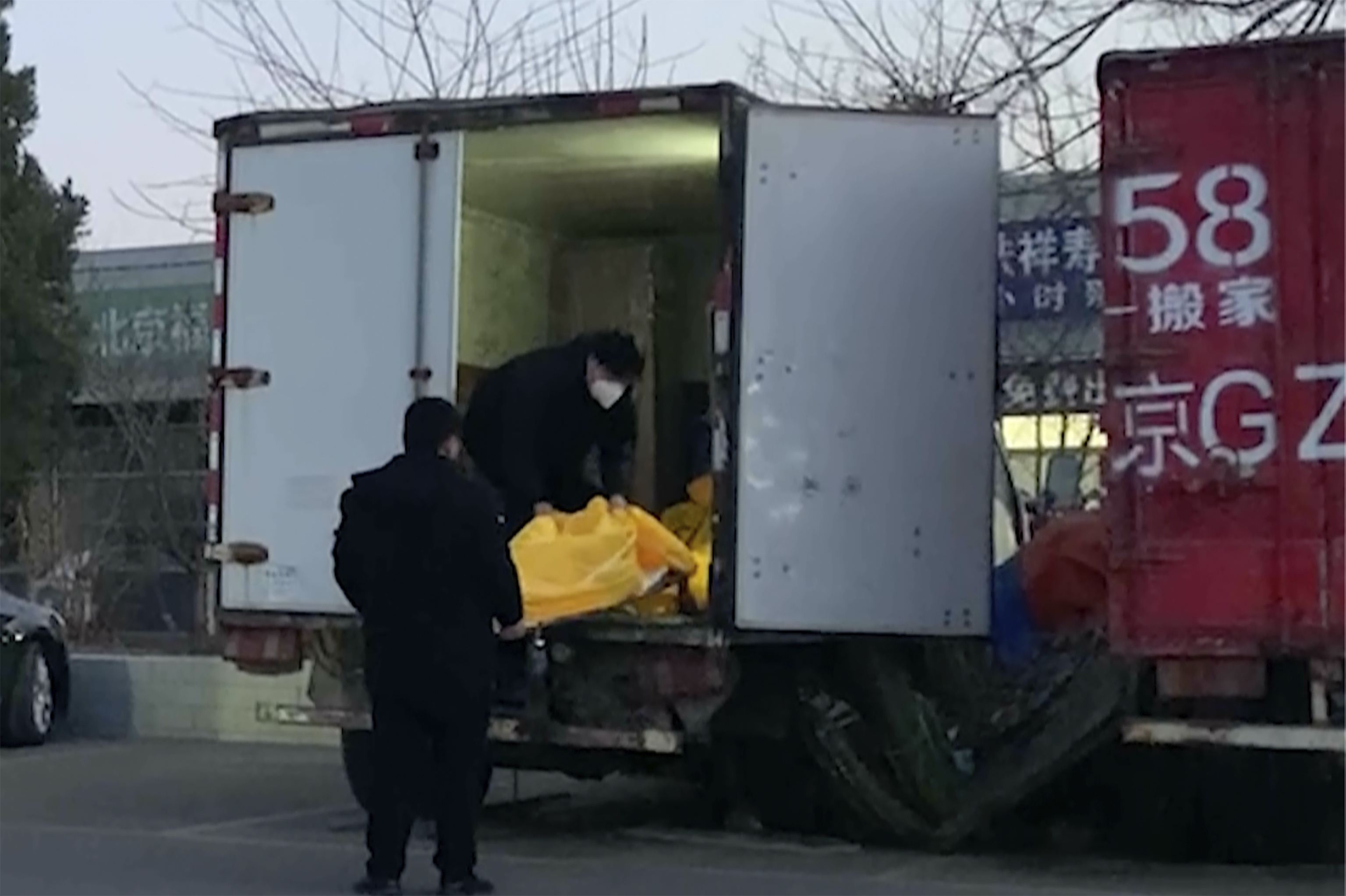 Trabajadores cargan bolsas con cadáveres en un camión en crematorio de Pekín.