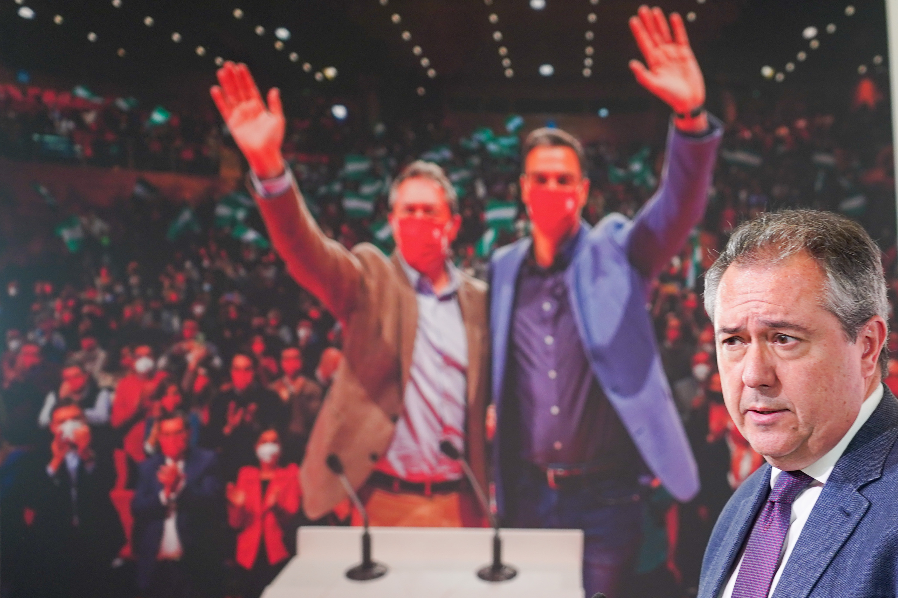 El secretario general del PSOE andaluz, Juan Espadas, en la sede el partido en Sevilla delante de una foto gigante de l con Pedro Snchez.