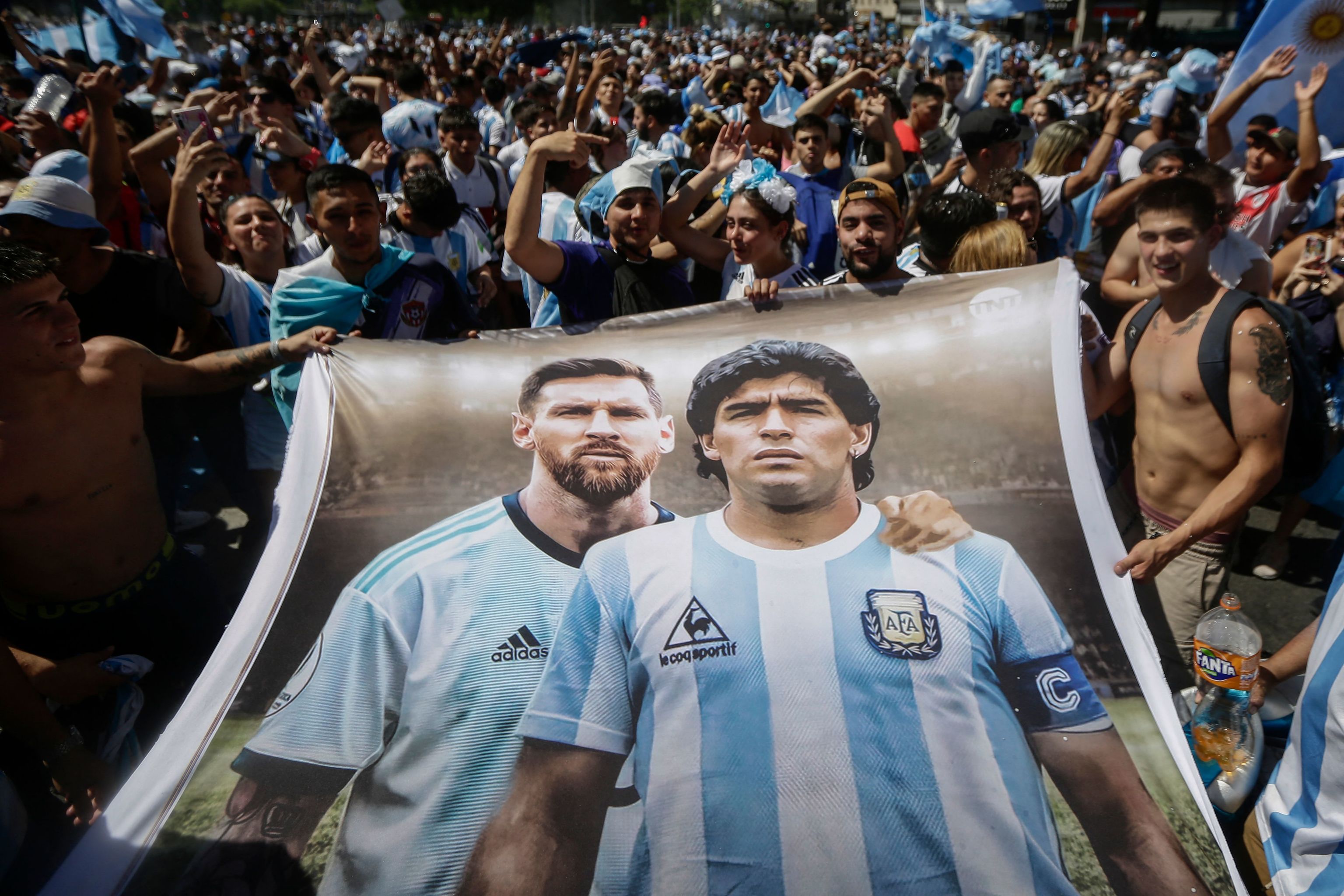 Seguidores argentinos con una bandera de Messi y Maradona.