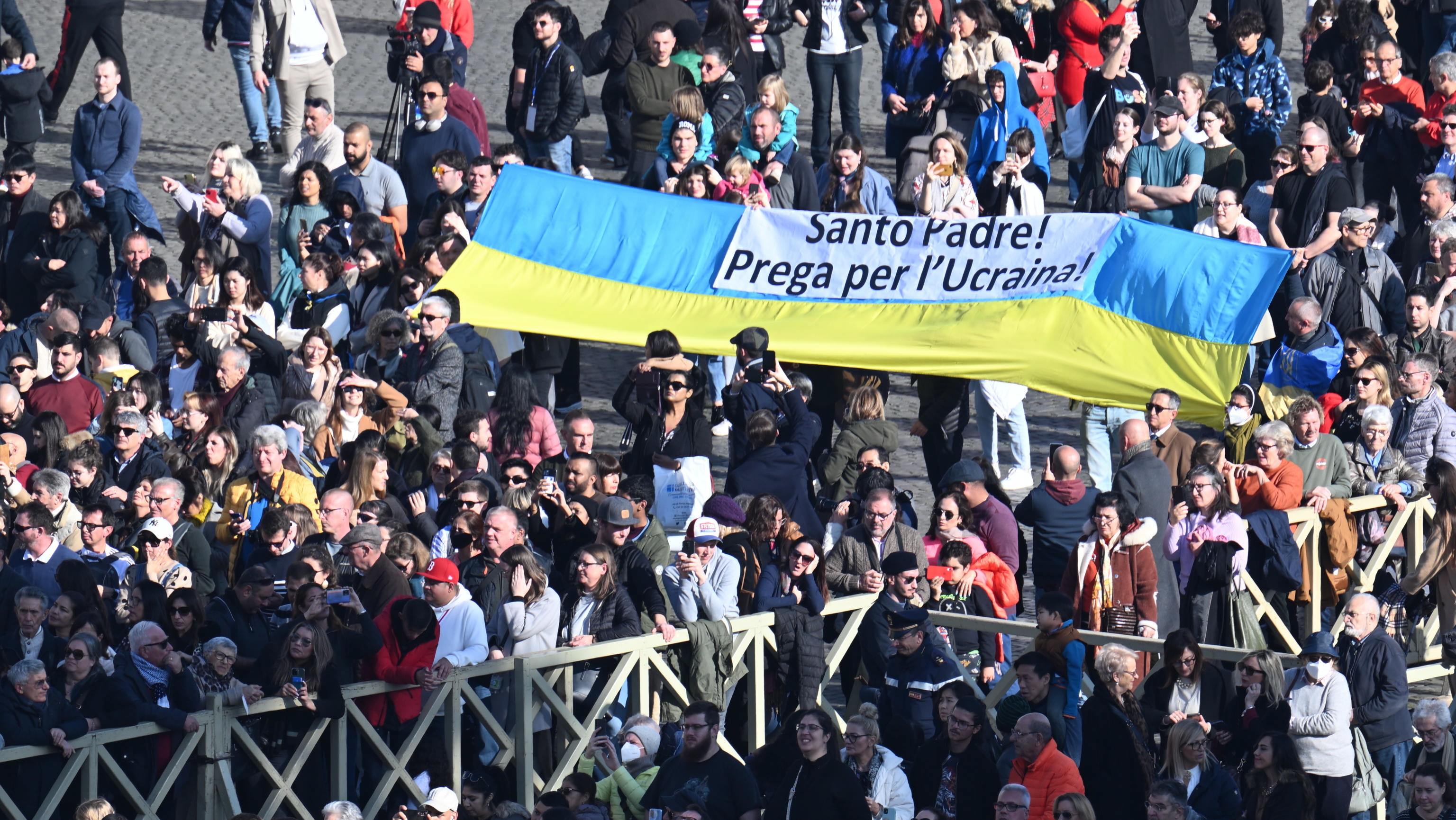 Varias personas sostienen una pancarta en apoyo a Ucrania.