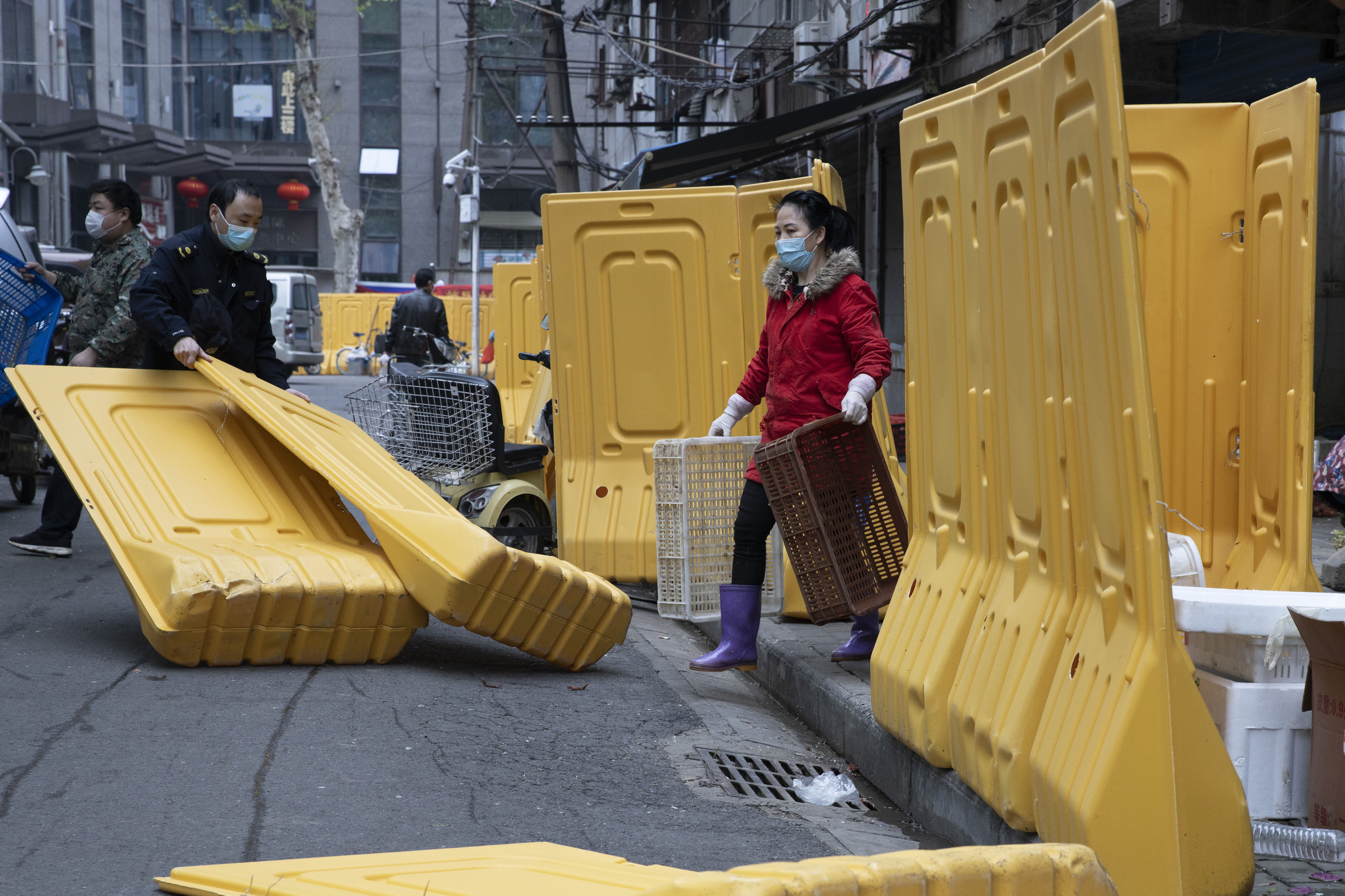 Retiran barreras de una comunidad, en Wuhan.