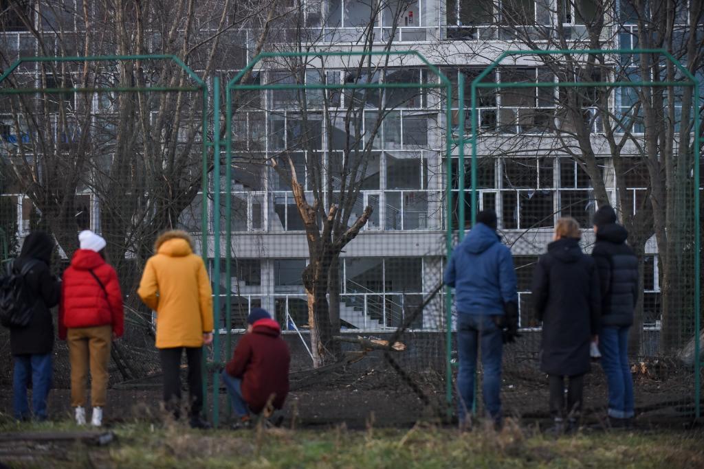 Un grupo de personas observa uno de los edificios destrozados por las bombas en Kiev.