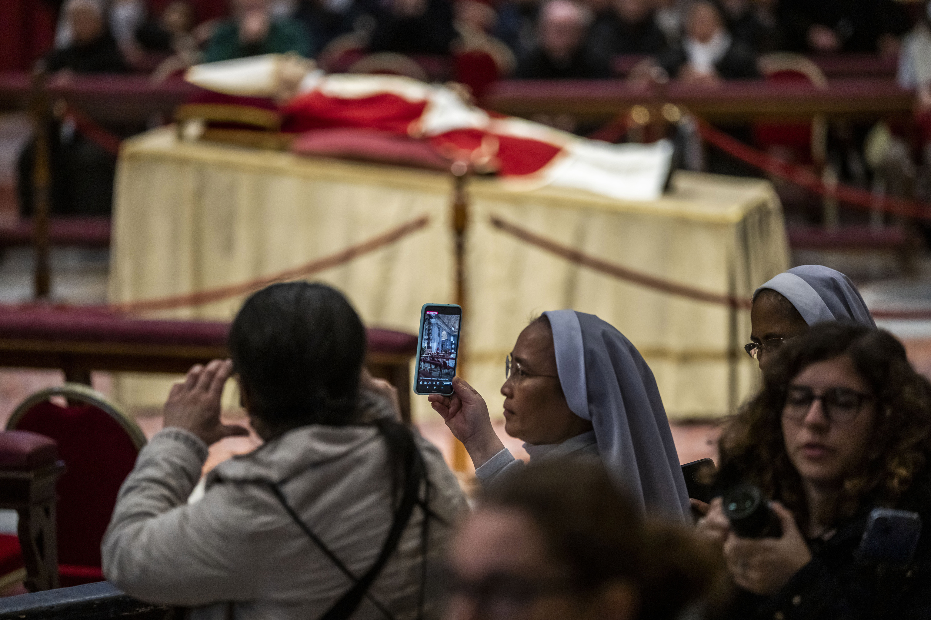 Varias personas desfilan ante el cuerpo del Papa Benedicto XVI instalada en el Vaticano.